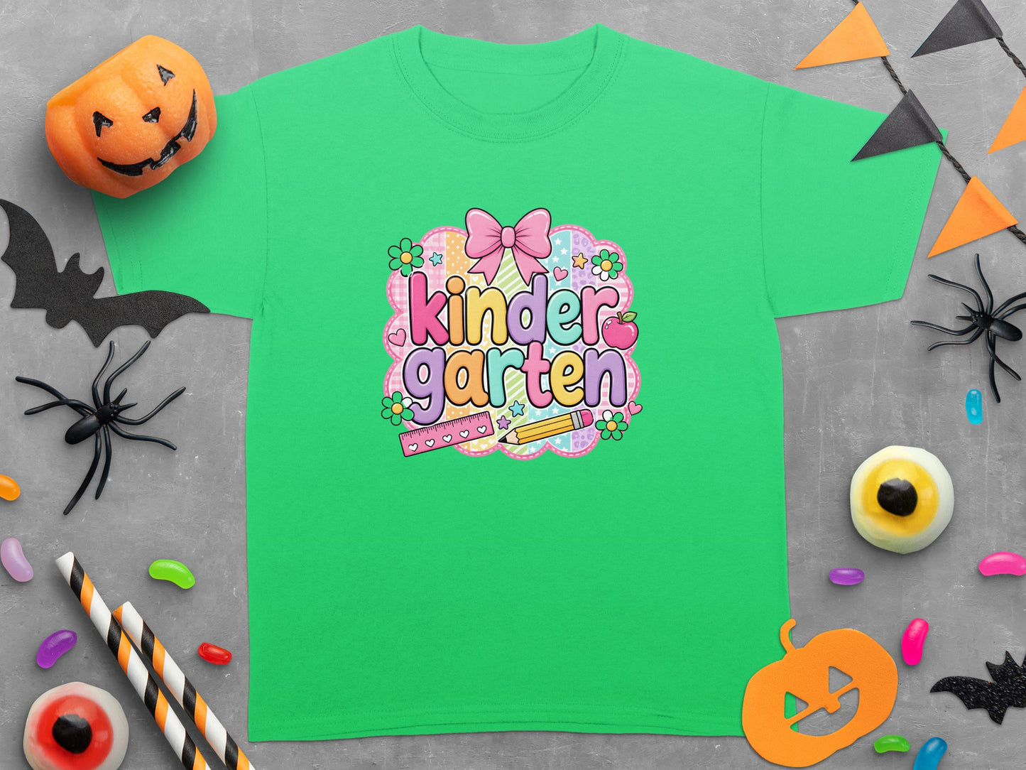 Green t-shirt with "kinder garten" text, pink bow, apple, pencil, and ruler graphic.