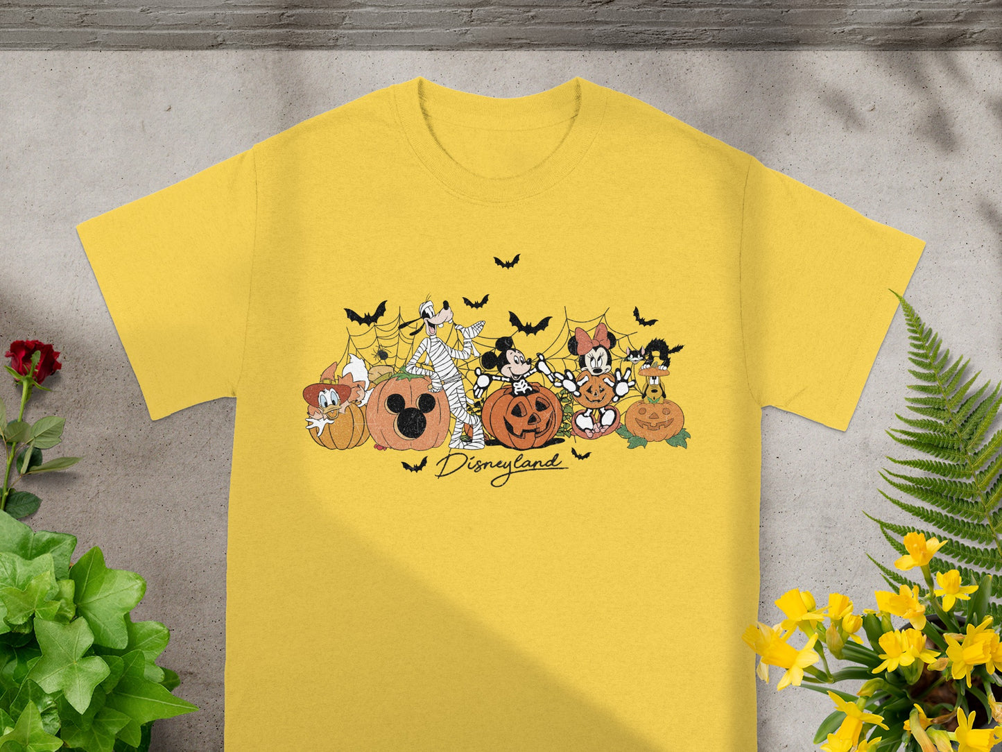 Yellow t-shirt with Disney characters and pumpkins, featuring the text "Disneyland".