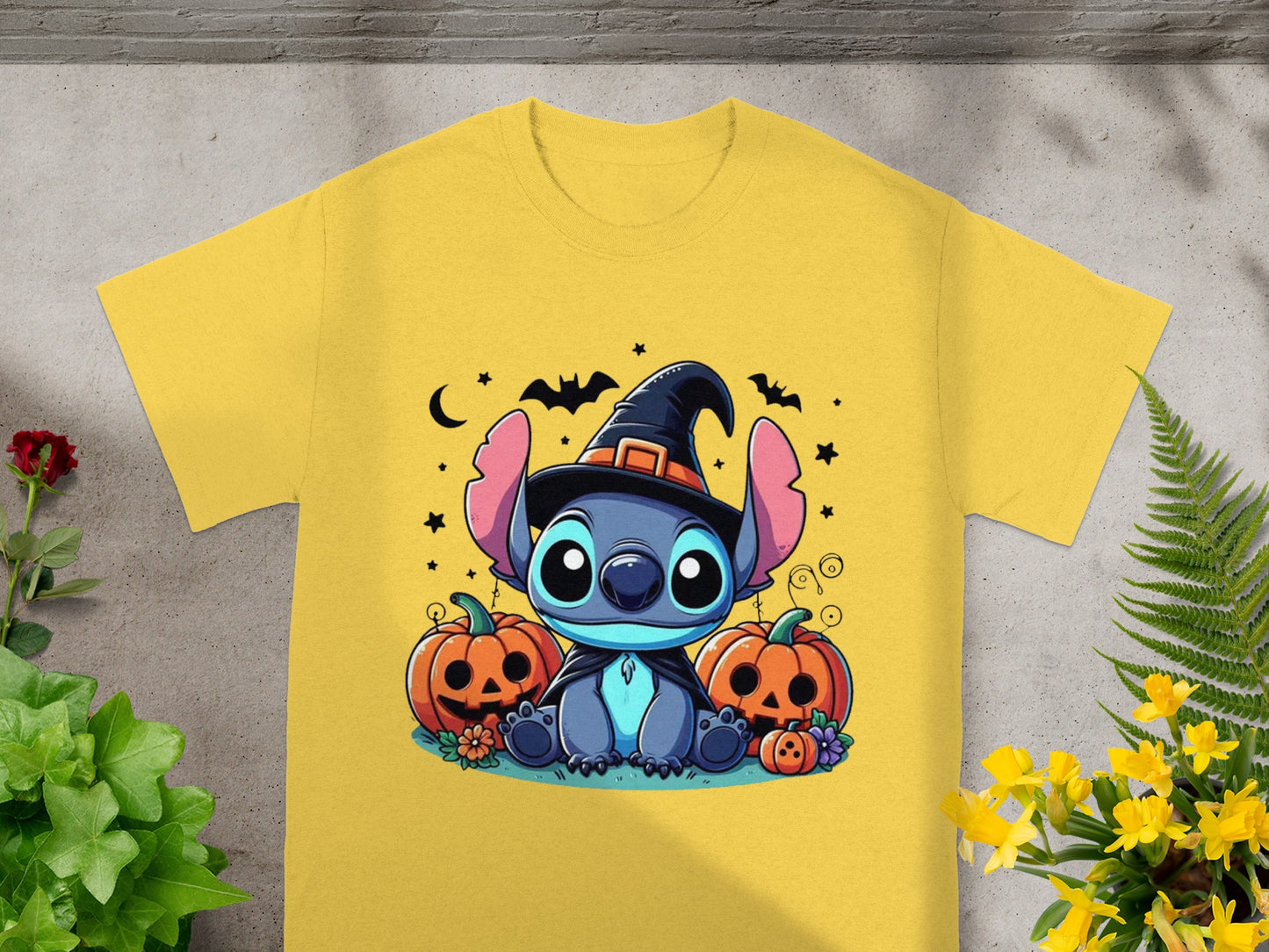 Stitch wearing witch hat with pumpkins and Halloween decorations on yellow t-shirt.