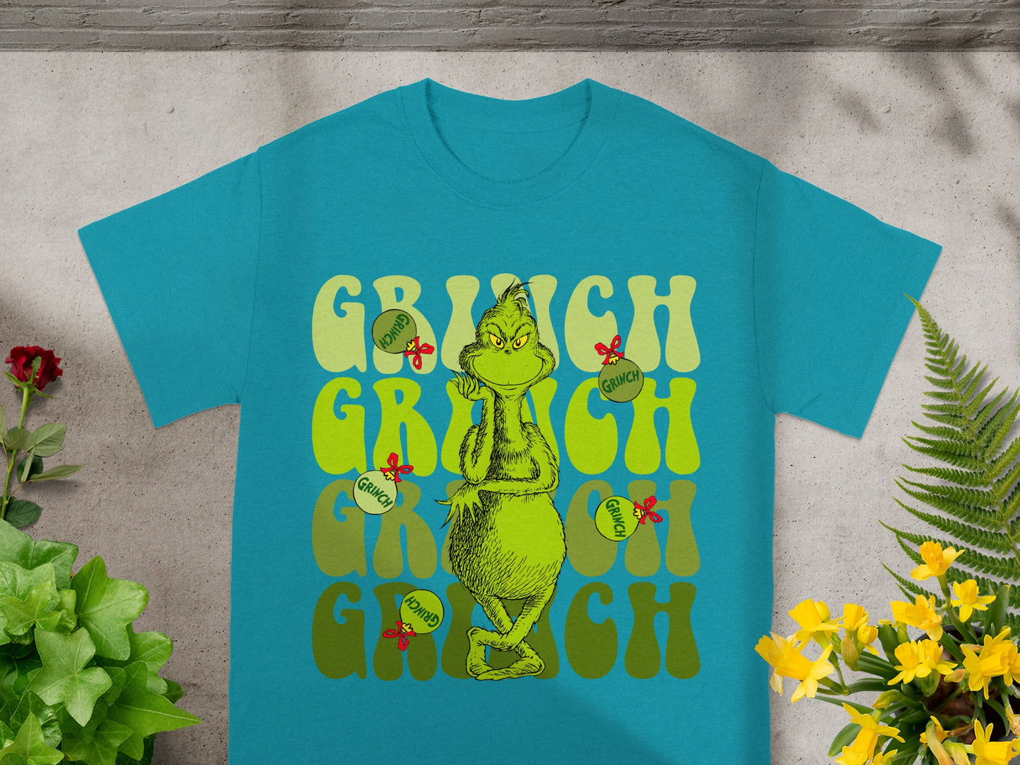 Teal t-shirt with the Grinch character and "GRINCH" text in green.