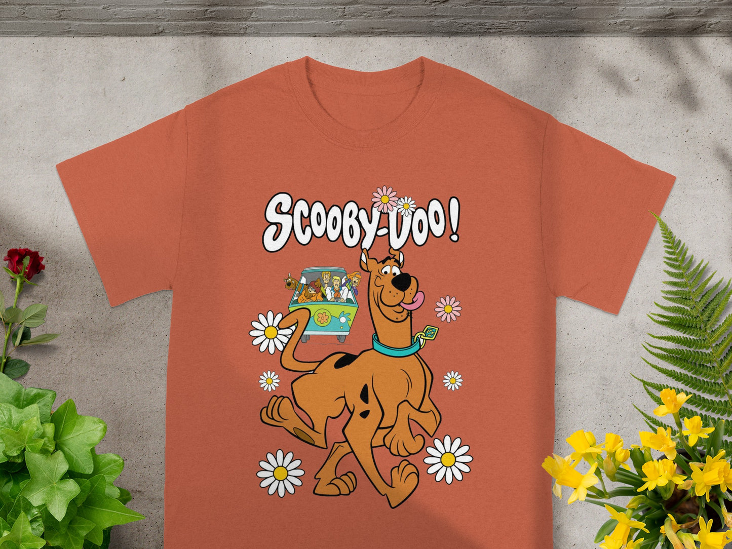 Scooby-Doo cartoon graphic on an orange t-shirt with daisies.