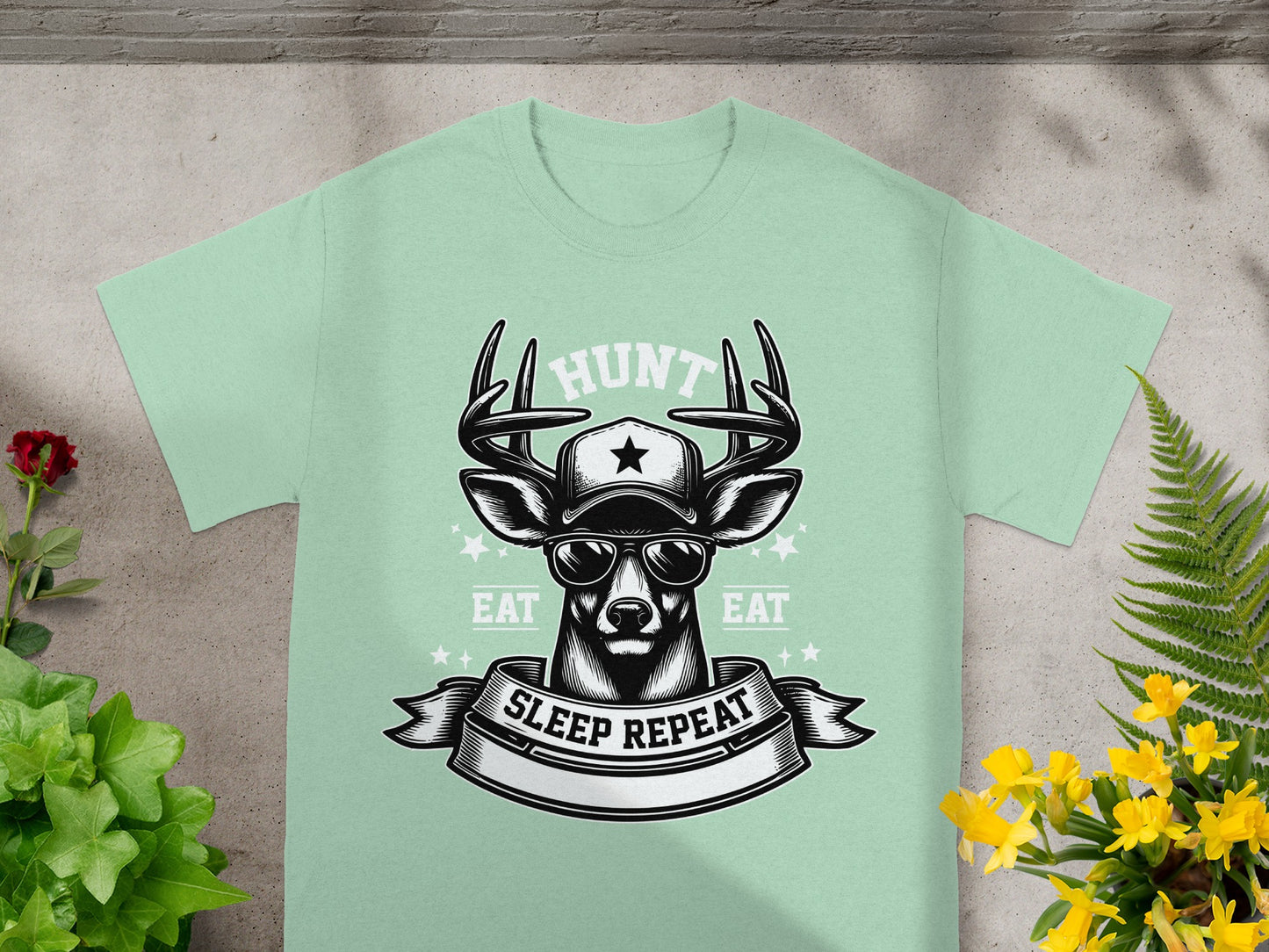 Light green t-shirt with deer wearing sunglasses and a cap, "HUNT" and "EAT SLEEP REPEAT" text.