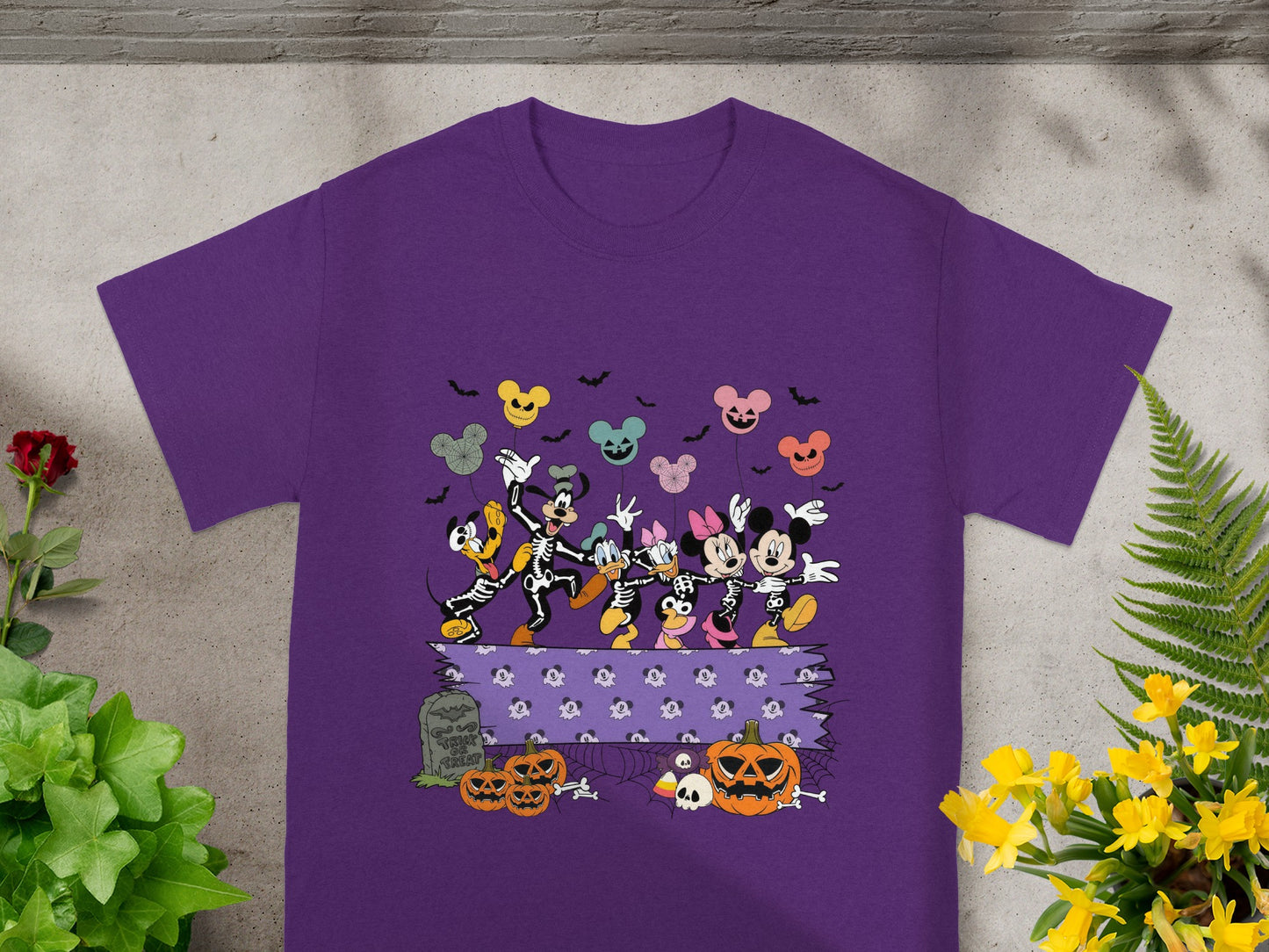 Mickey Mouse and friends in skeleton costumes dance with Halloween pumpkins and balloons.