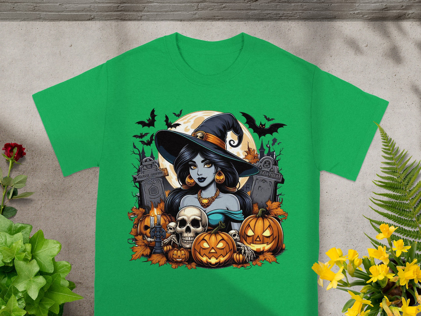 Green t-shirt with Halloween graphic of witch, pumpkins, skulls, bats, and tombstones.