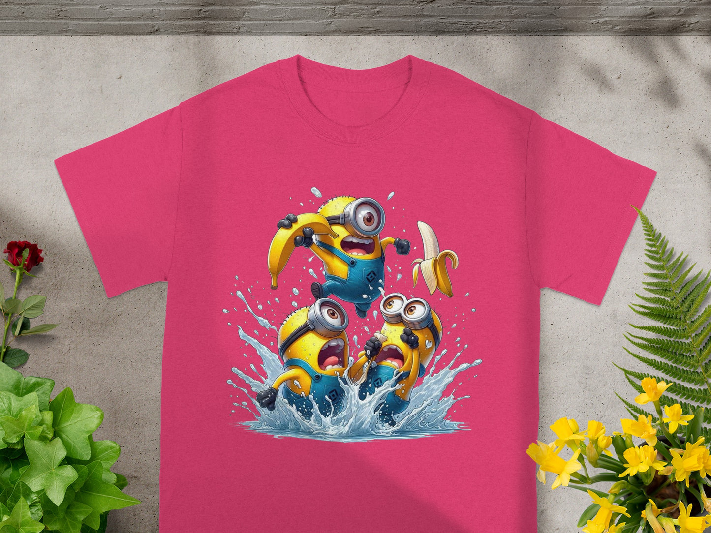 Three Minions splashing water while holding a banana, on a pink t-shirt.