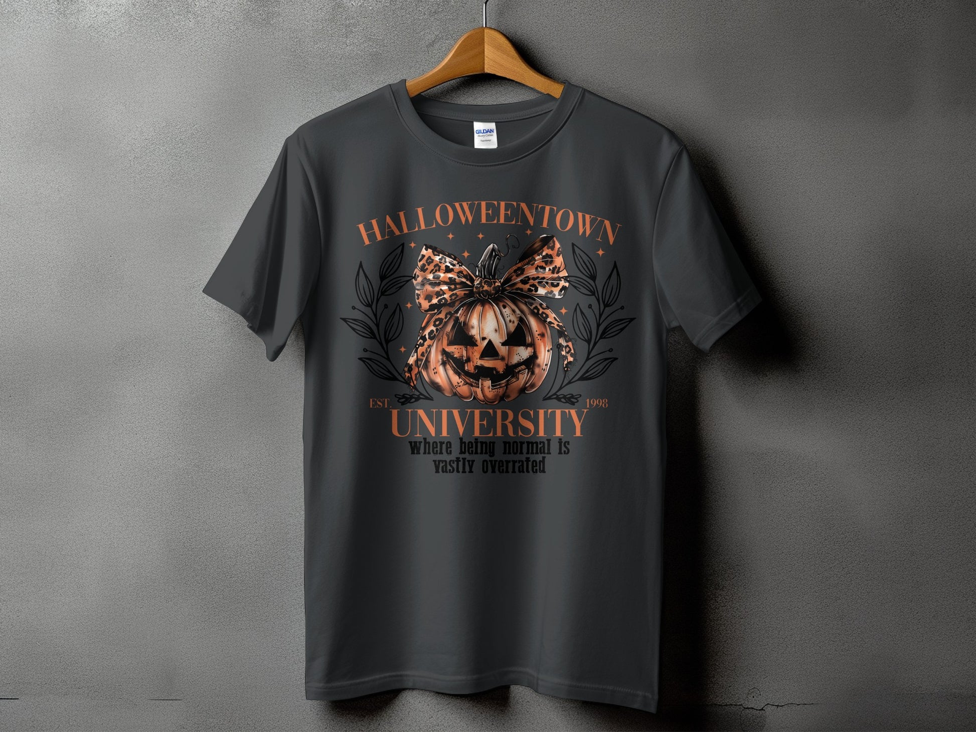 Dark gray t-shirt with Halloween graphic featuring a pumpkin, leopard bow, and text.