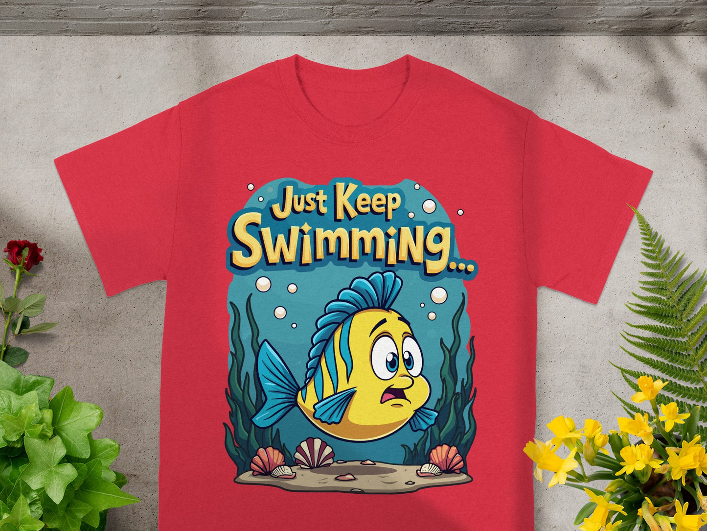 Yellow and blue fish with "Just Keep Swimming..." text on a red t-shirt.