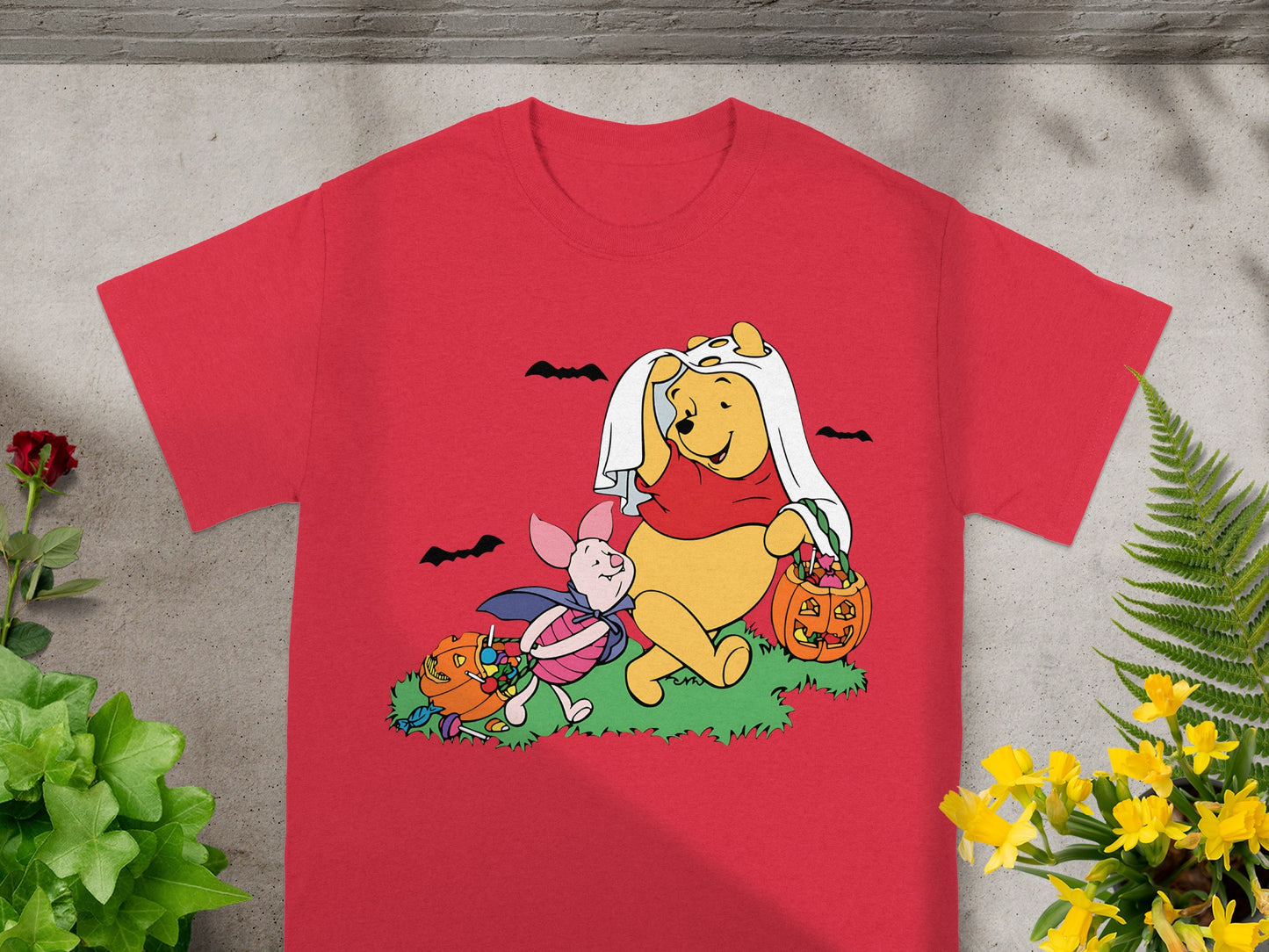 Winnie the Pooh and Piglet in Halloween costumes collecting candy from pumpkins.
