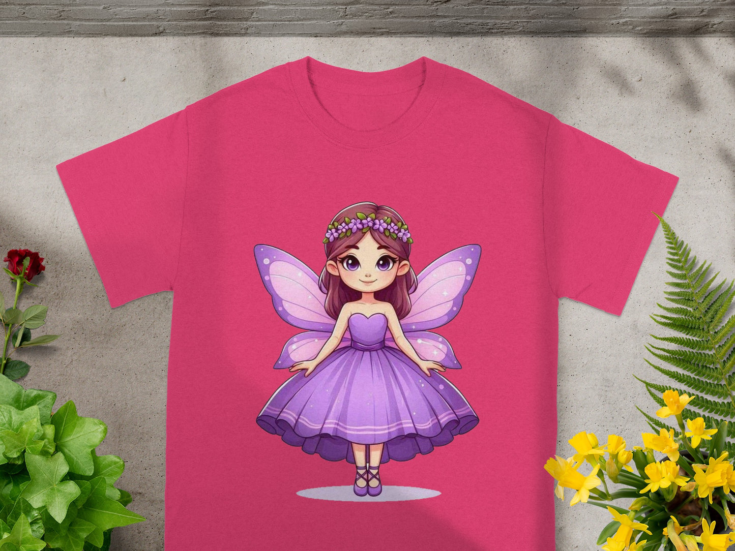 Pink t-shirt with a cartoon fairy in a purple dress, wings, and flower crown.