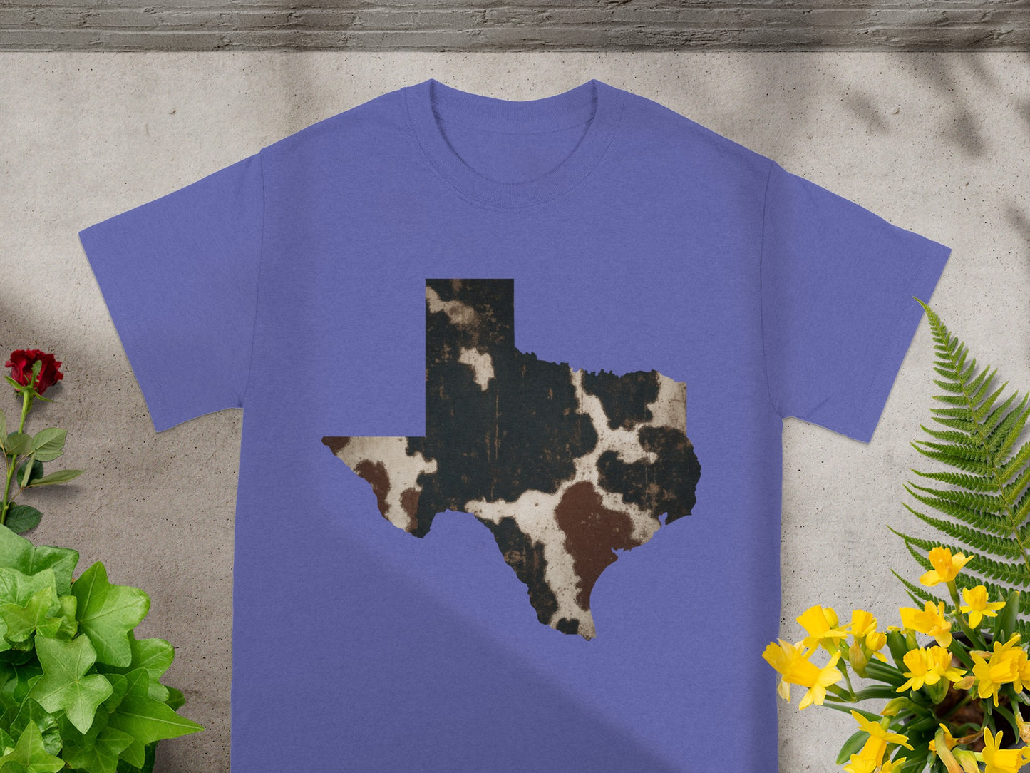 Purple t-shirt with Texas map graphic in cow print pattern.