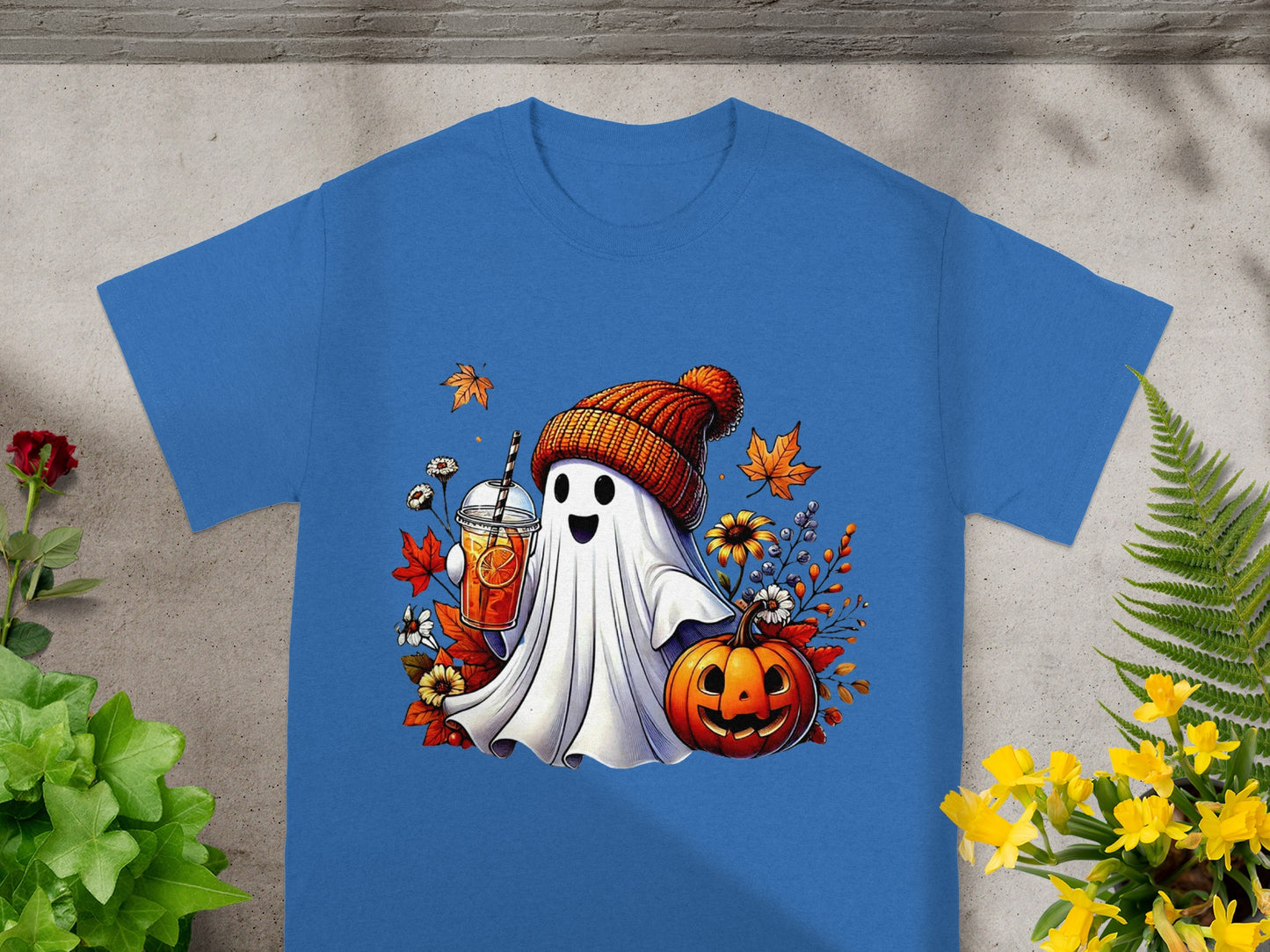 Ghost wearing beanie, holding drink, with pumpkin and fall leaves.