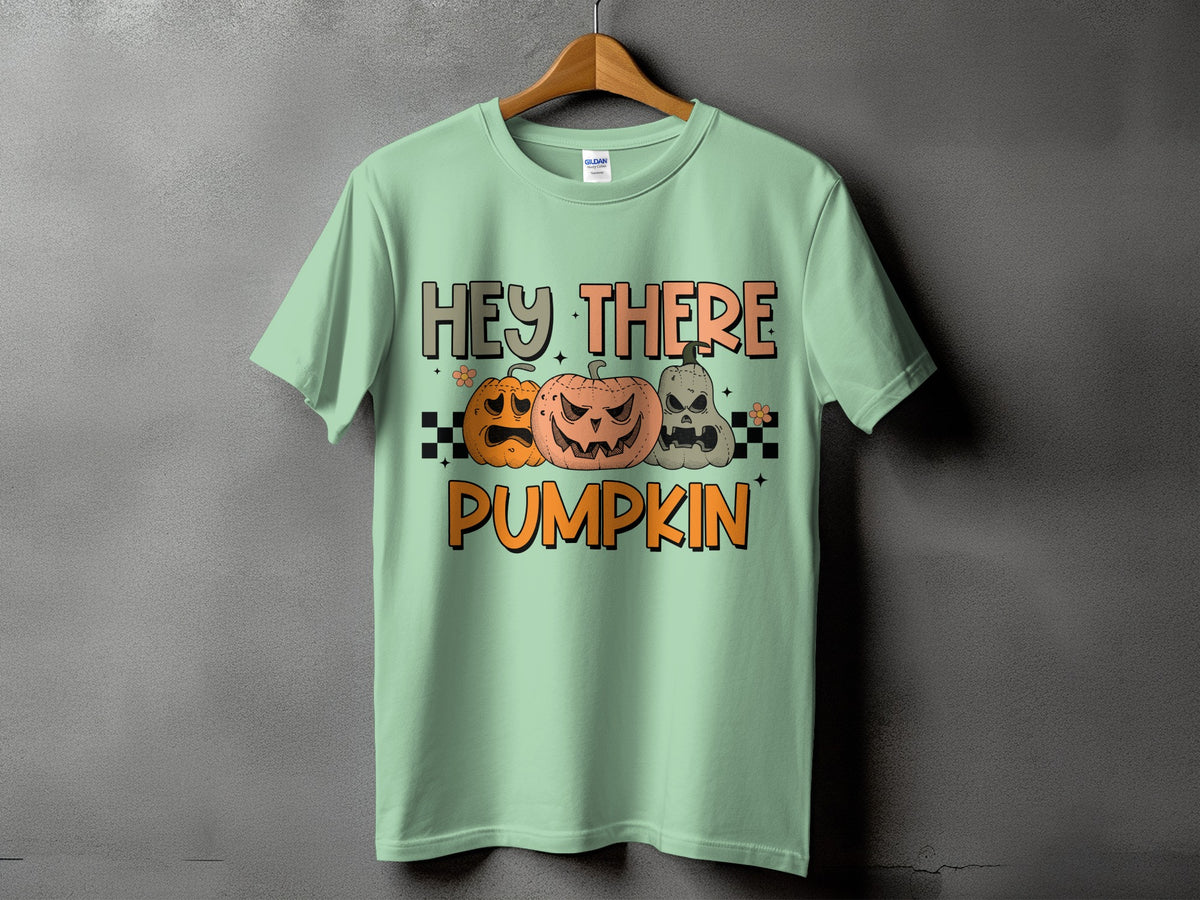 Light green t-shirt with "Hey There Pumpkin" and three carved pumpkins.