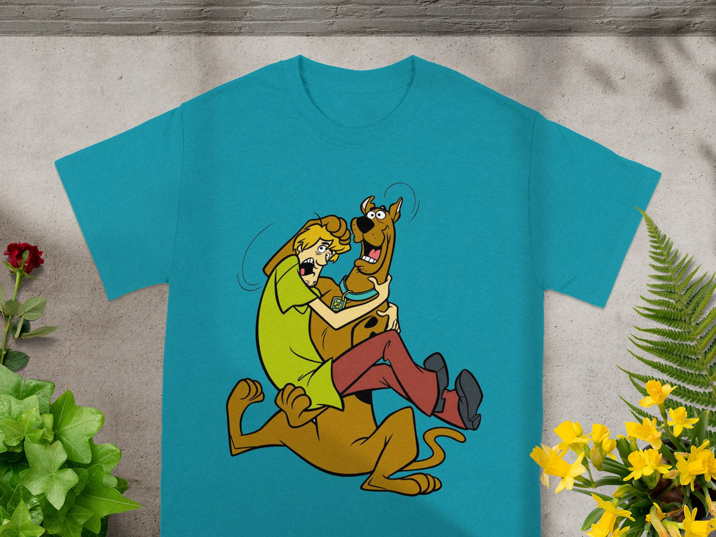 Shaggy embraces Scooby-Doo in a playful hug on a teal t-shirt.