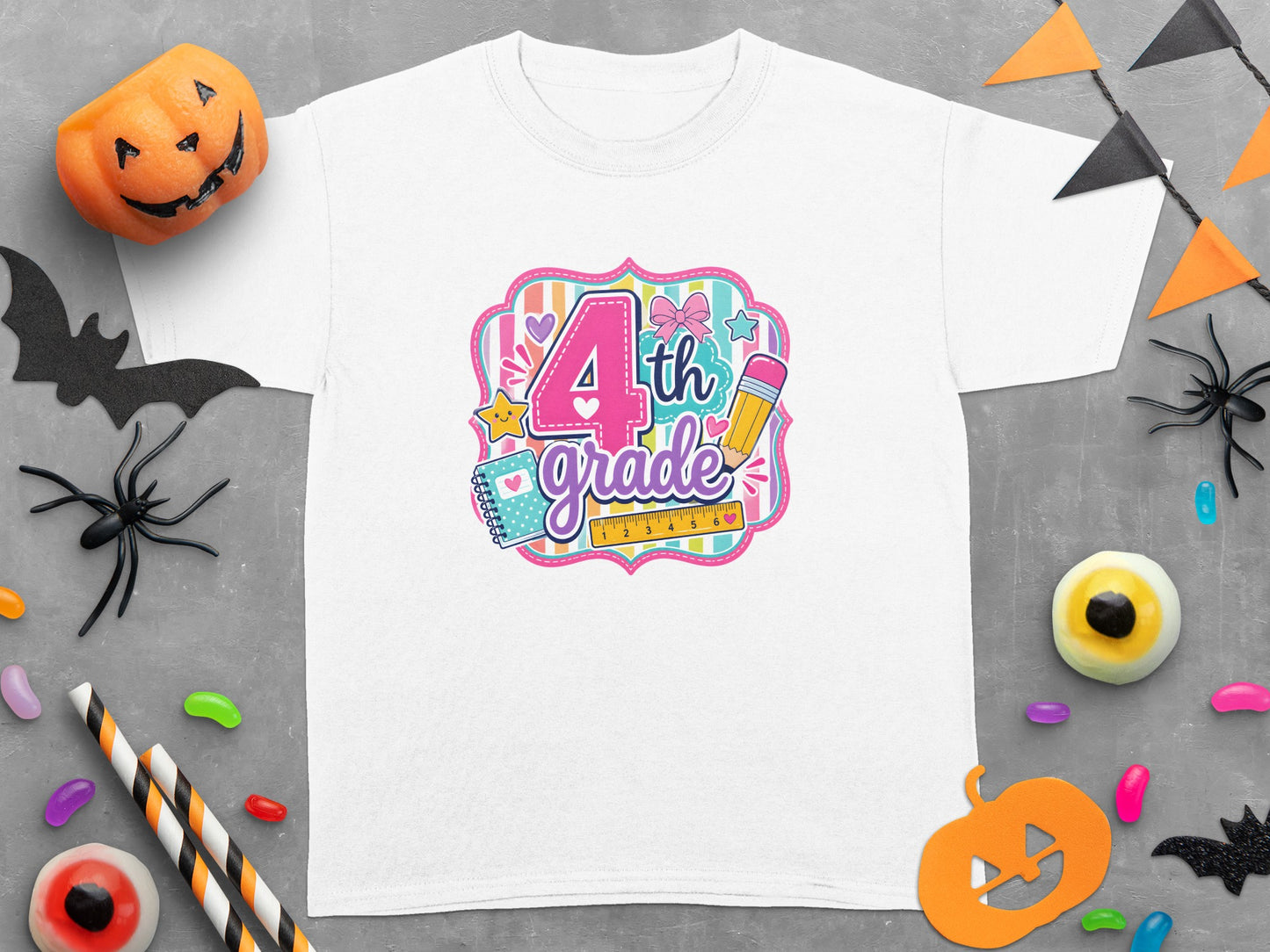 White t-shirt with colorful "4th grade" graphic, surrounded by Halloween decorations.