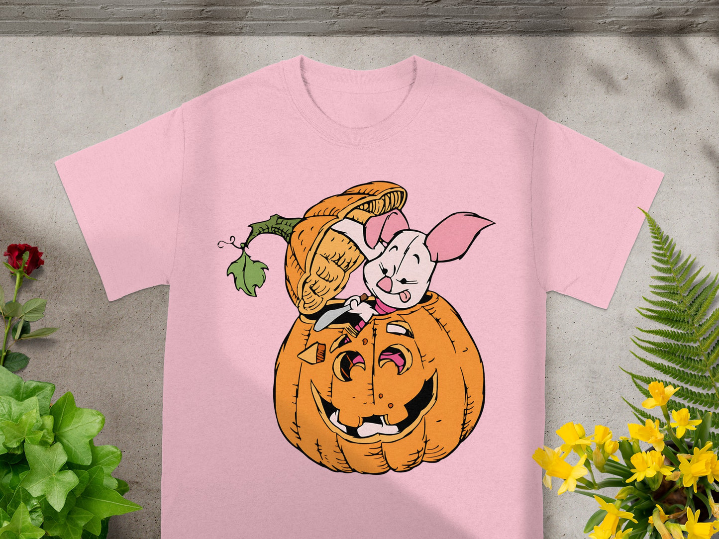 Pink t-shirt with cartoon Piglet emerging from a jack-o'-lantern.