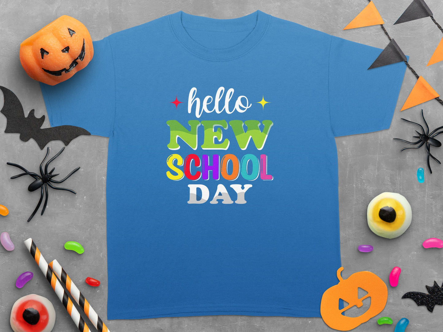 Blue t-shirt with "hello NEW SCHOOL DAY" text, surrounded by Halloween decor.