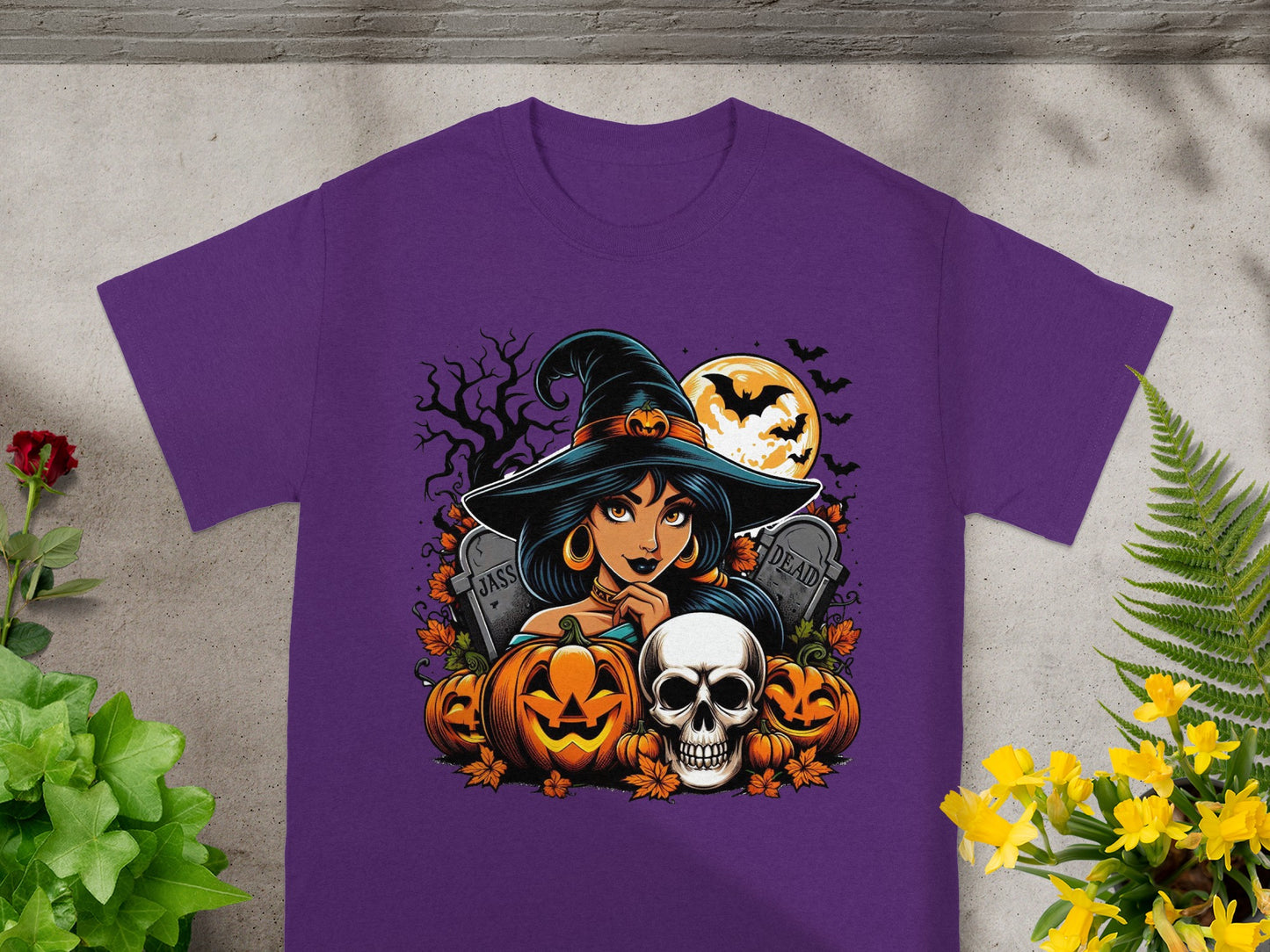 Purple t-shirt featuring a Halloween graphic with a witch, pumpkins, and skulls.