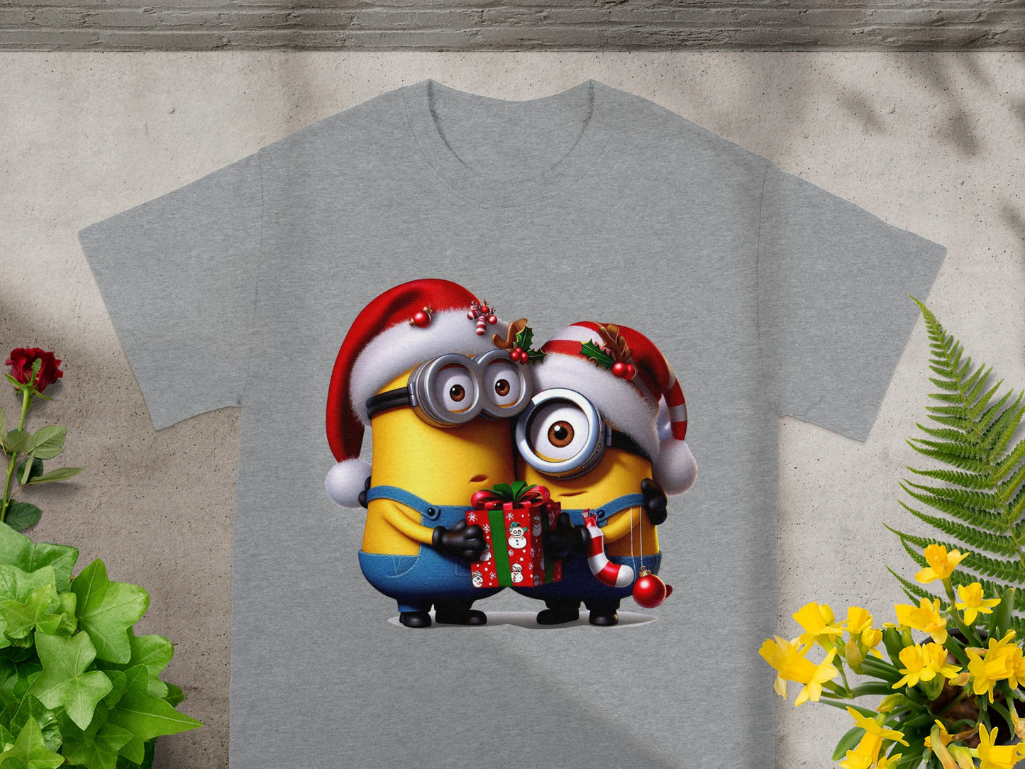 Two Minions in Santa hats embrace, holding a Christmas gift.