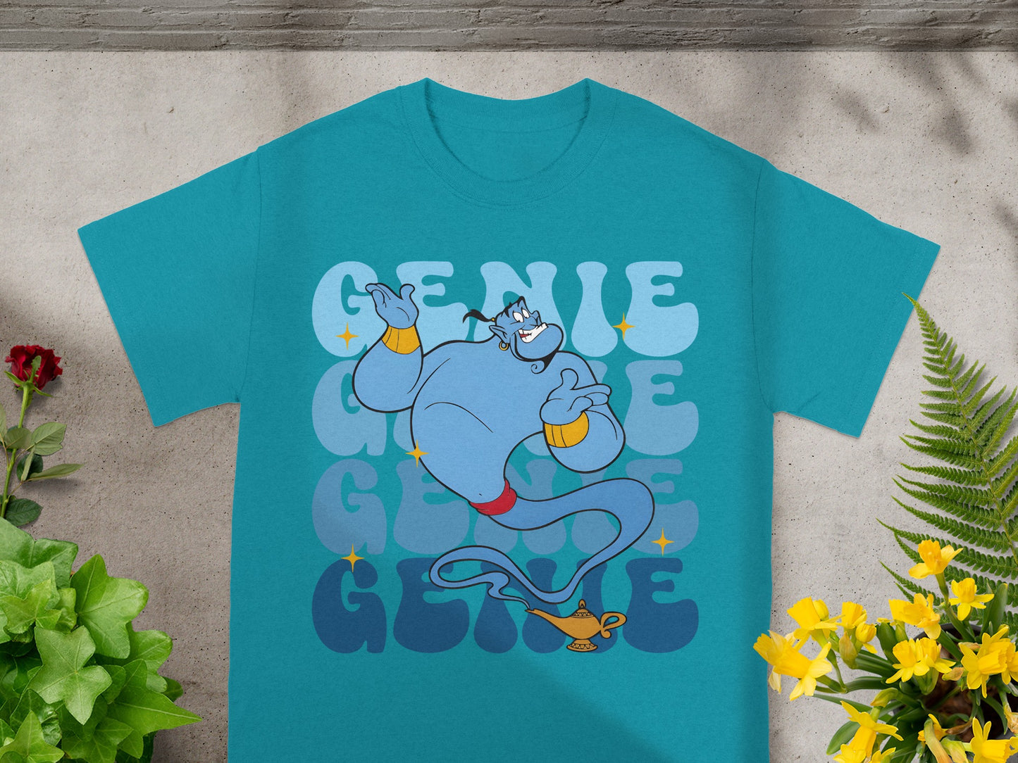 Blue genie from Aladdin with a magic lamp on a teal t-shirt.