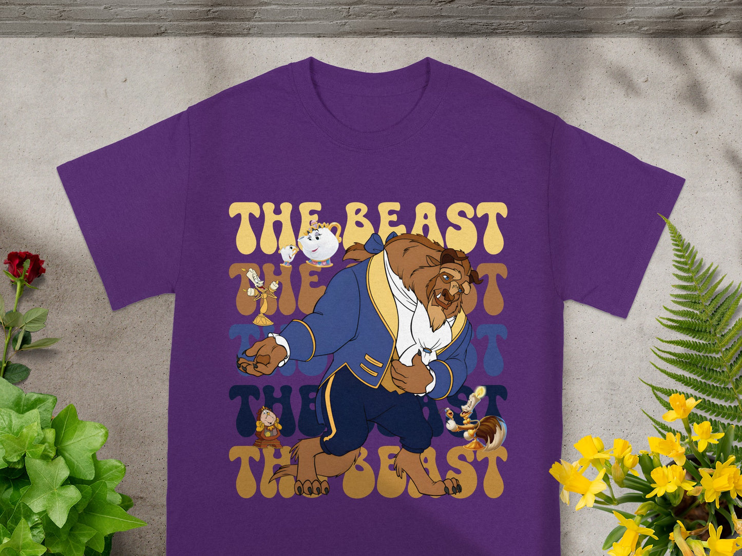 Purple t-shirt with "The Beast" text and cartoon characters of Beast, Mrs. Potts, and Chip.