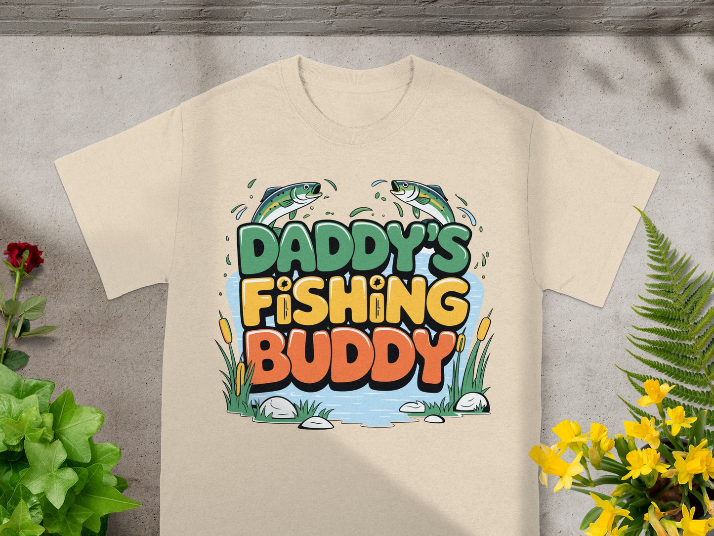 Tan t-shirt with "DADDY'S FISHING BUDDY" text and two jumping fish.