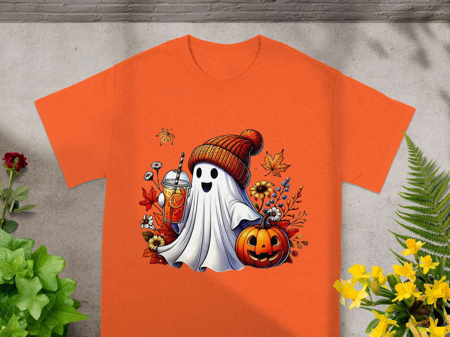Ghost wearing beanie holding drink with pumpkin and fall leaves.