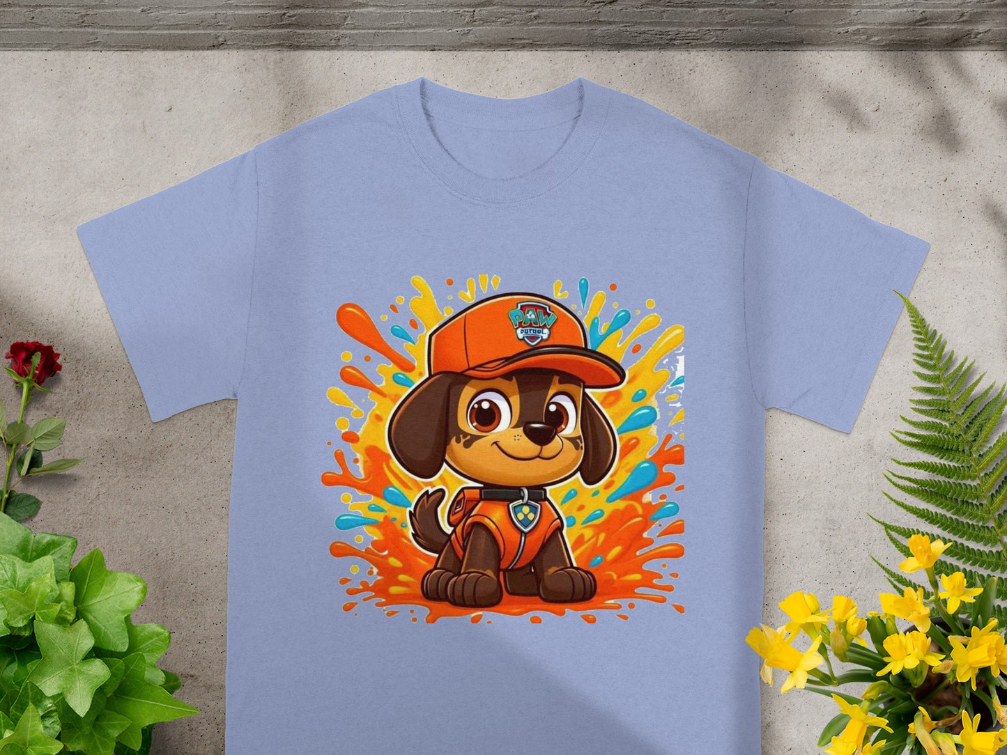 Paw Patrol Marshall character on a light blue t-shirt with colorful paint splatters.