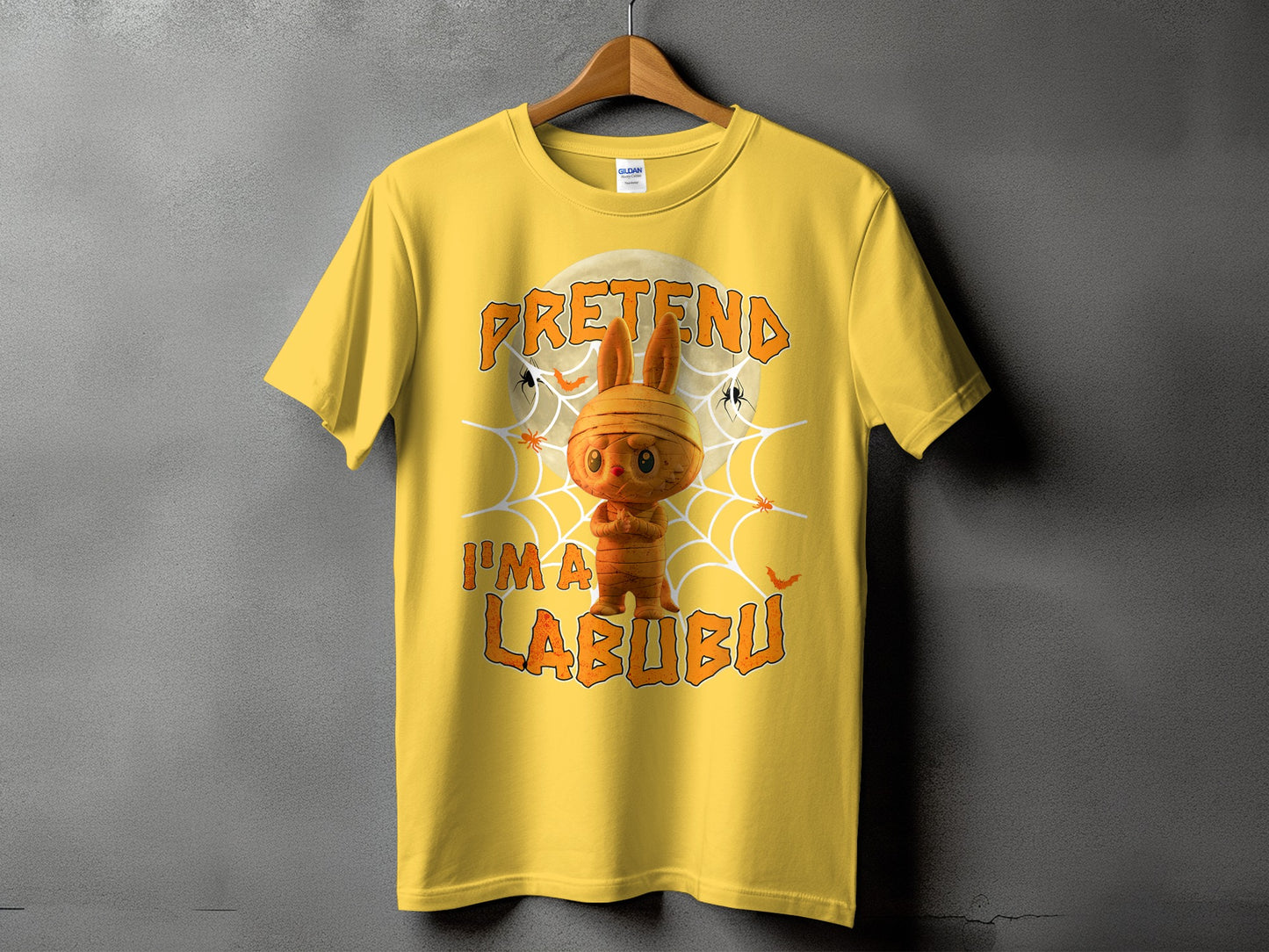 Yellow t-shirt with mummy Labubu character and text "PRETENDA I'M A LABUBU".