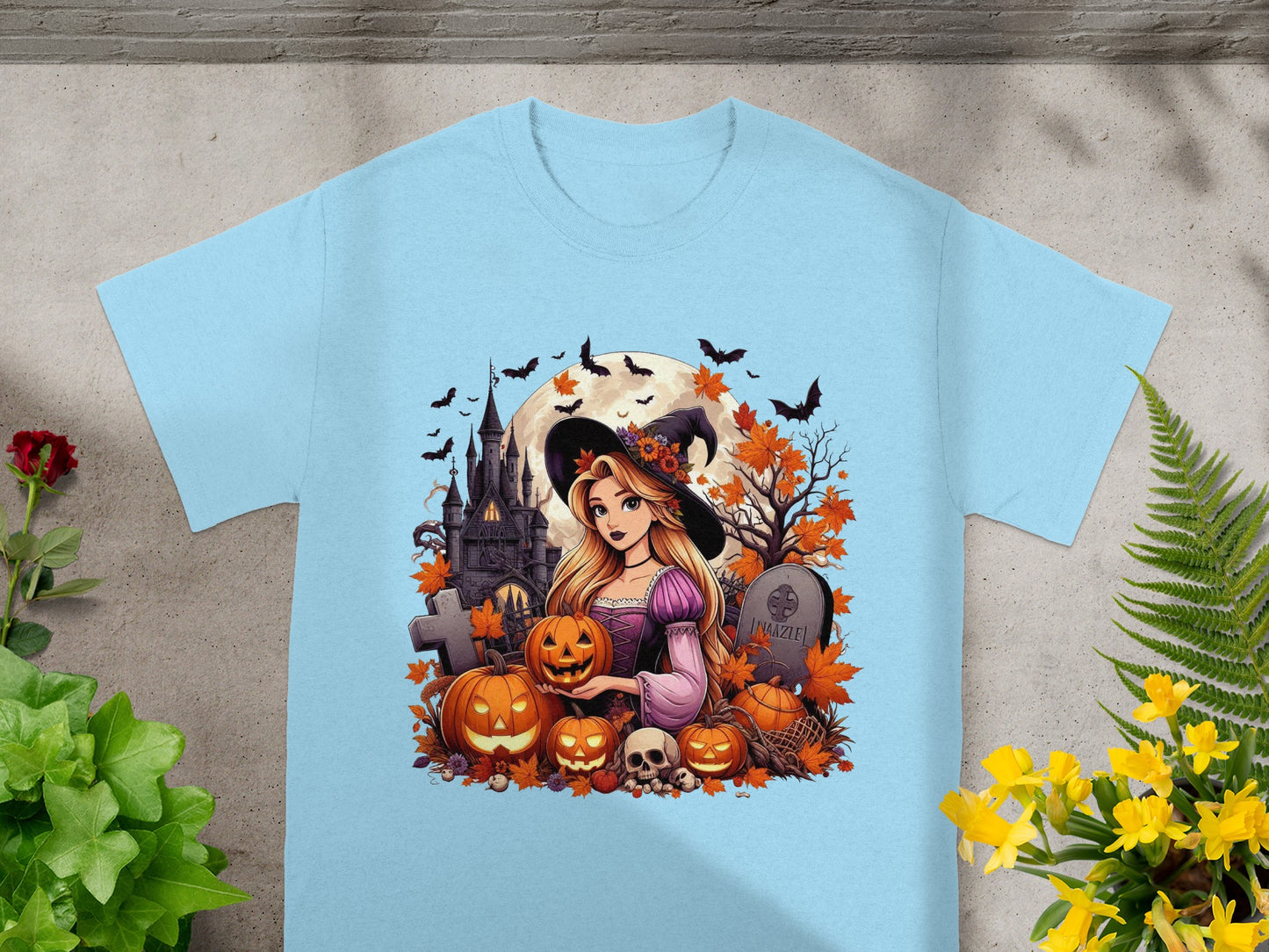 Light blue t-shirt with Halloween graphic featuring witch, pumpkins, castle, bats, and tombstone with text.
