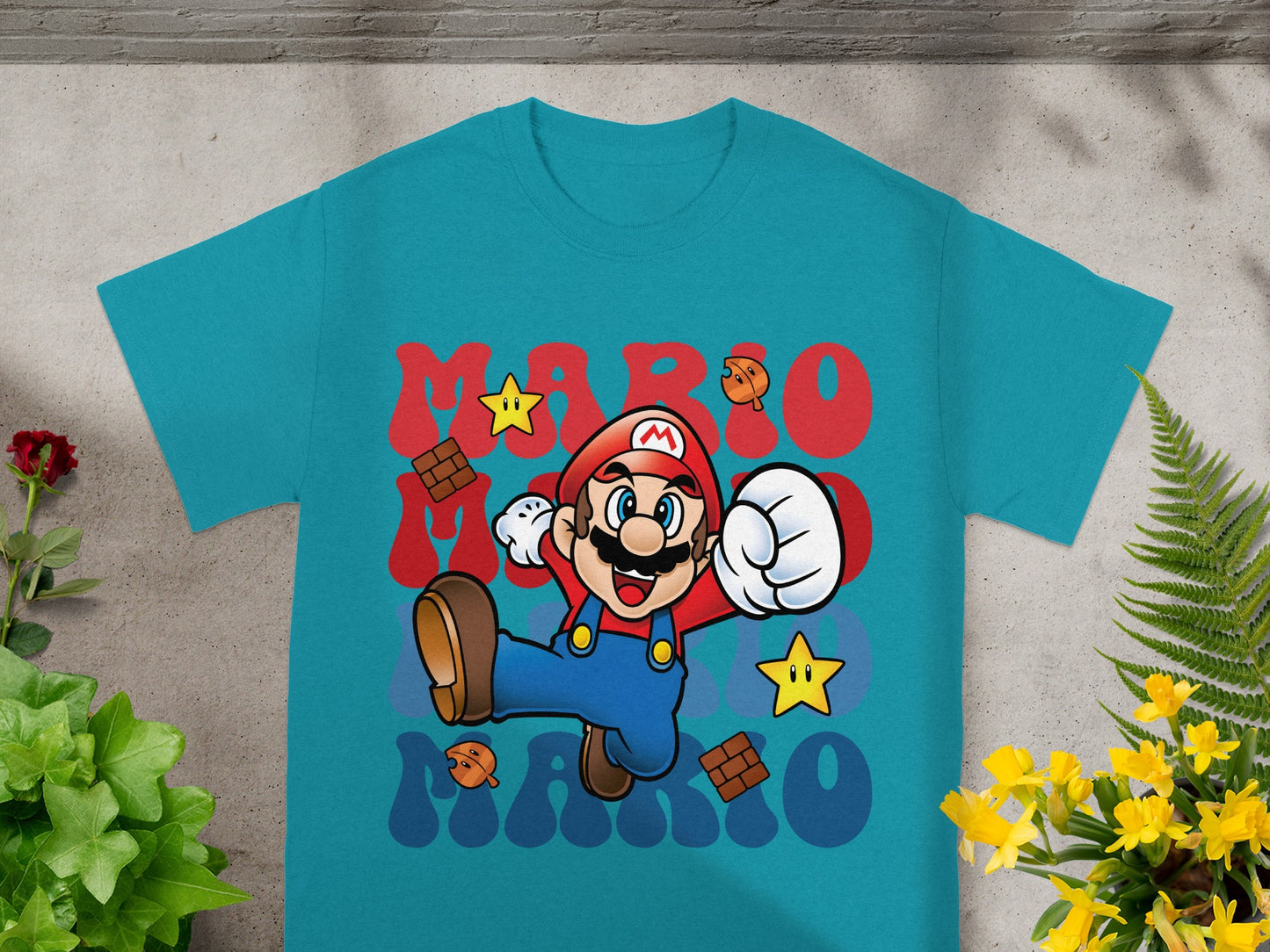 Mario character with stars and bricks graphic on a teal t-shirt.