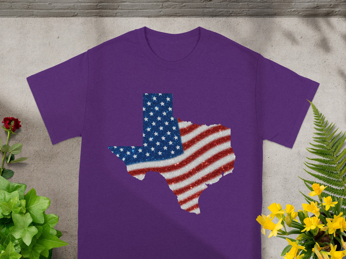 Purple t-shirt with glitter Texas flag design and floral accents.