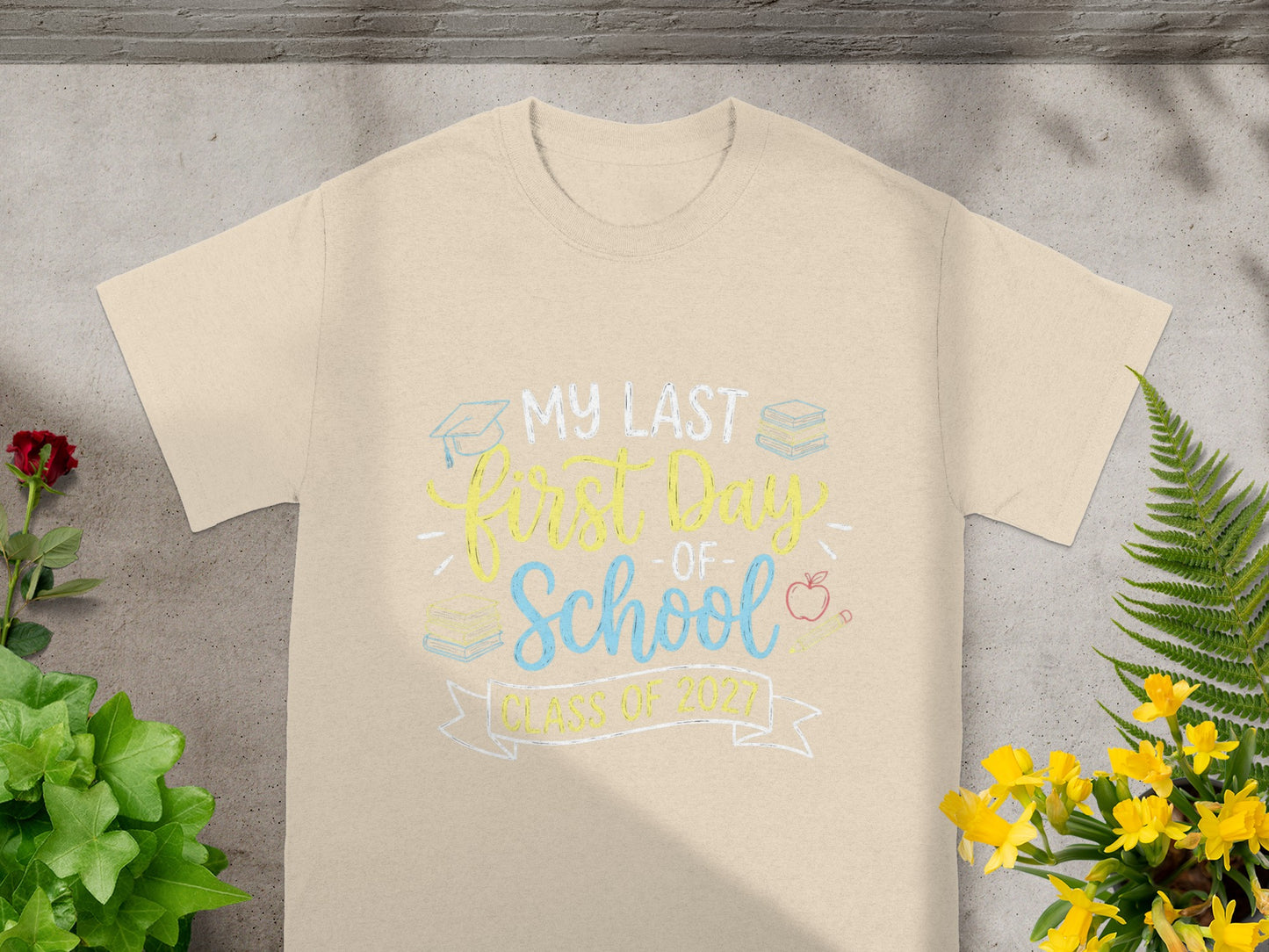 Light tan t-shirt with "My Last First Day of School Class of 2027" graphic.