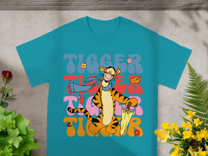 Tigger character with umbrella and leaves on teal t-shirt.