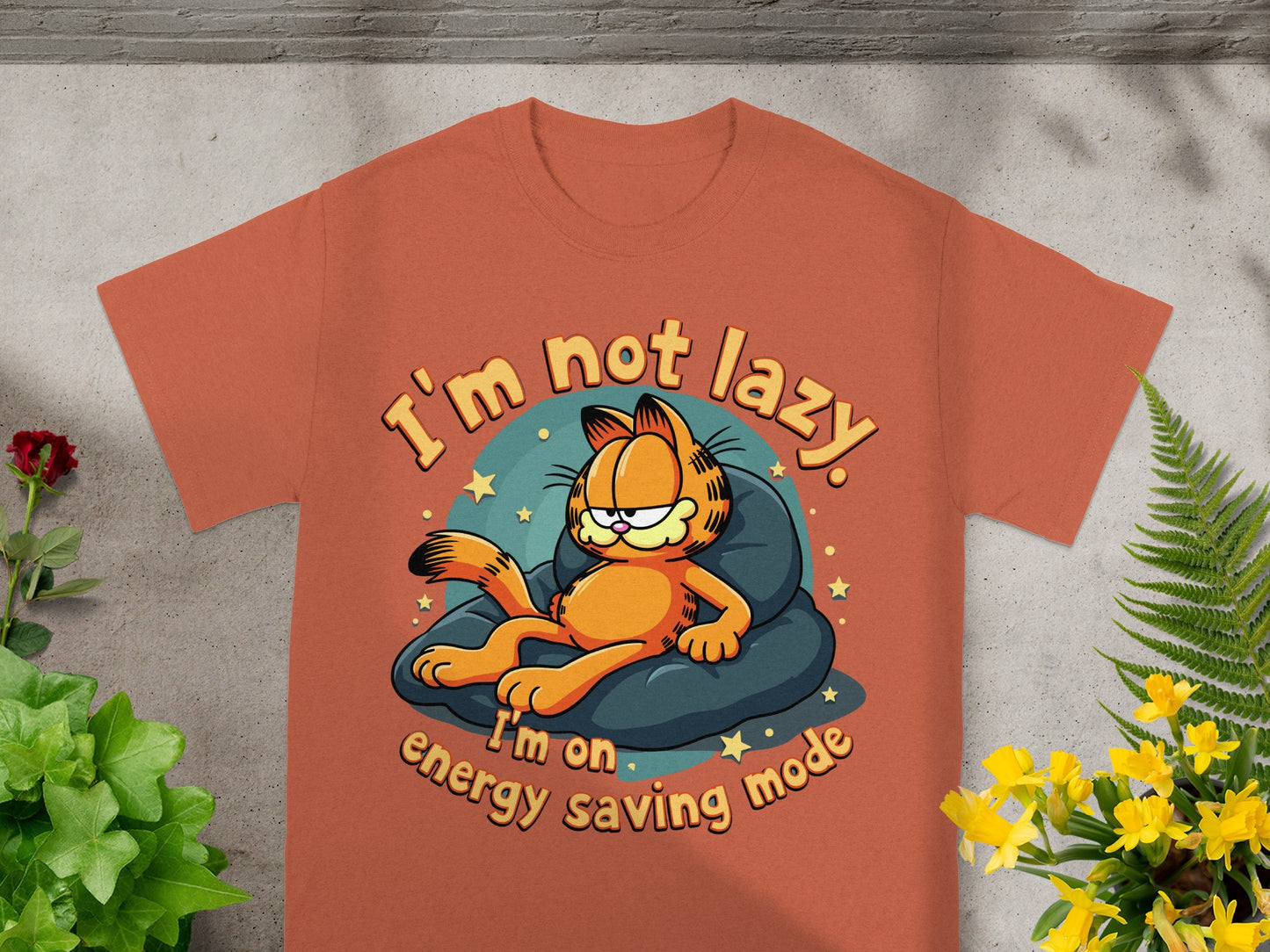 Orange t-shirt with Garfield lounging on a pillow, text "I'm not lazy. I'm on energy saving mode."