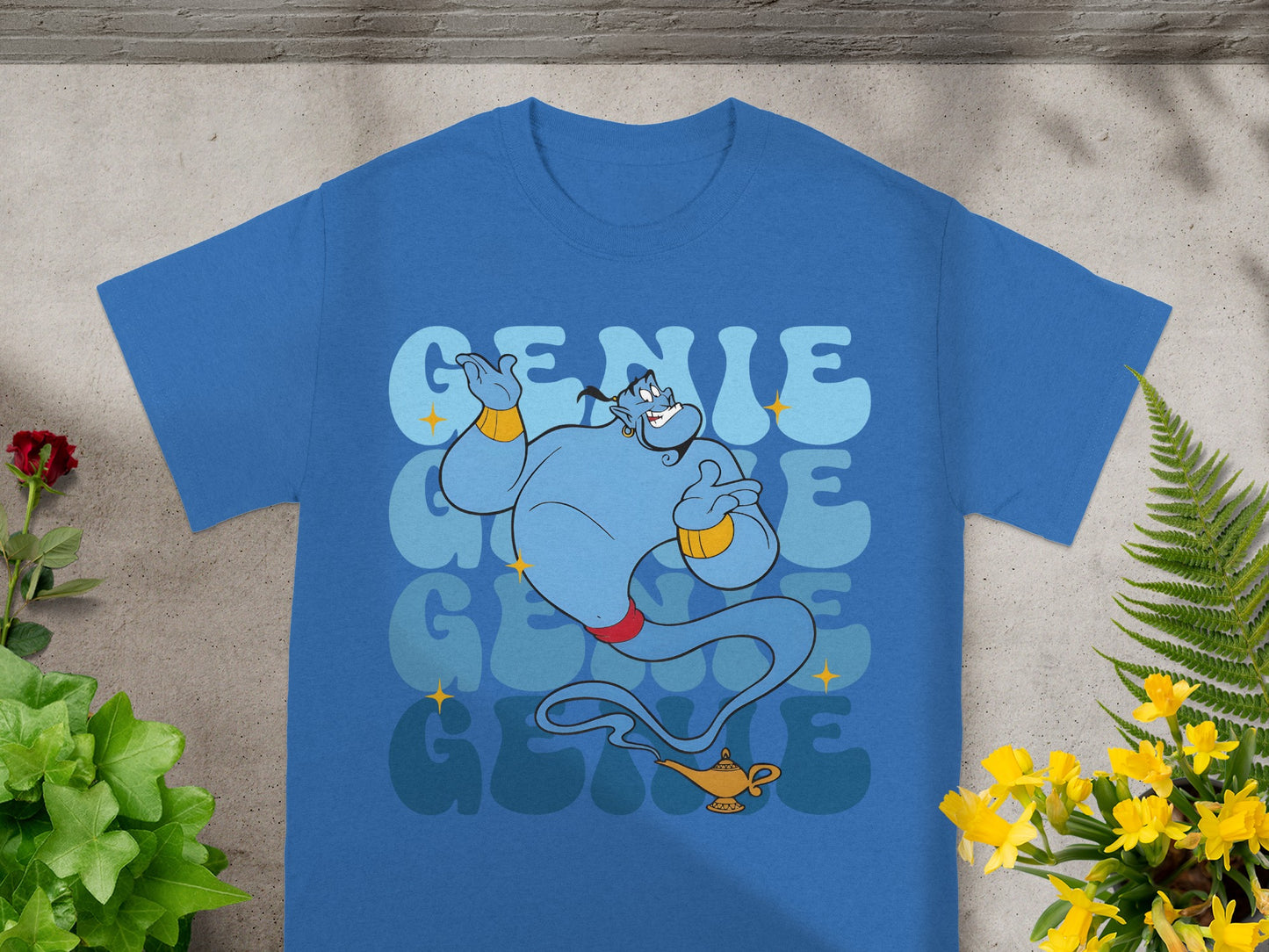 Blue t-shirt featuring a cartoon genie and Aladdin's lamp with the word "Genie".