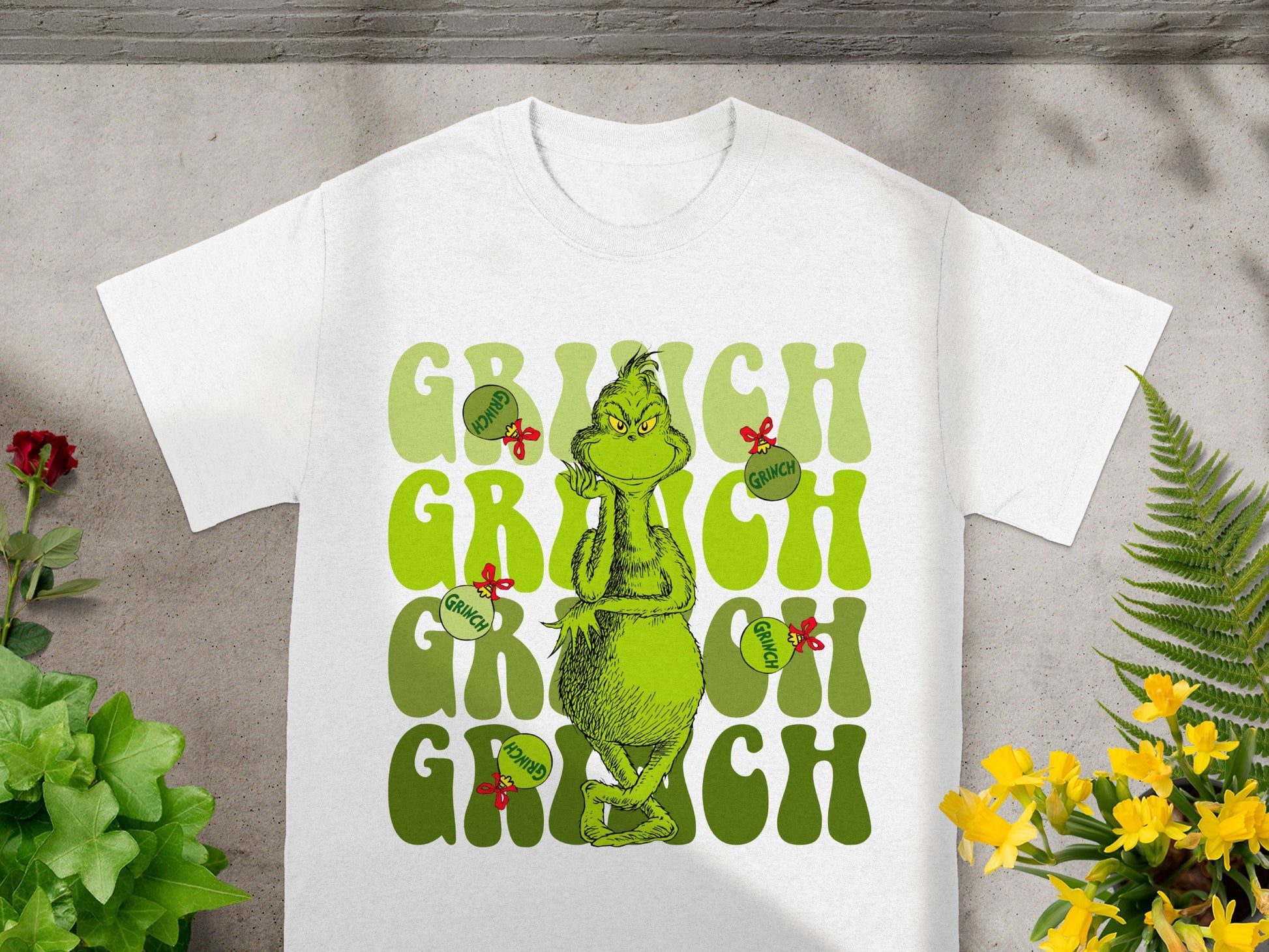 White t-shirt with Grinch graphic and repeated "GRINCH" text.