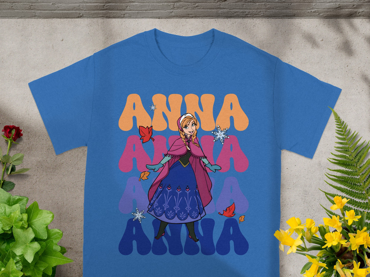 Blue t-shirt with Anna from Frozen character graphic and colorful text.