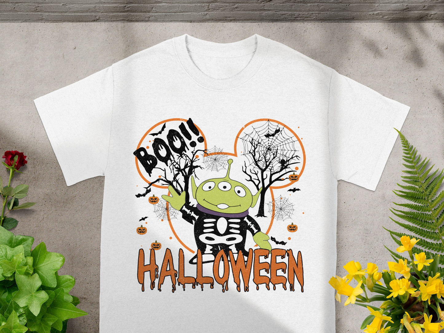 White t-shirt with alien in skeleton costume and "Boo!!" and "Halloween" text.