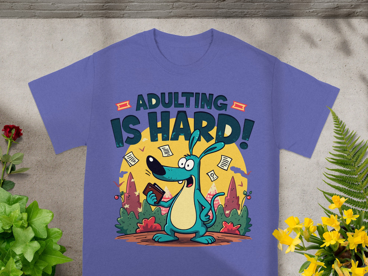 Purple t-shirt with a blue cartoon dog holding a wallet and text "ADULTING IS HARD!".