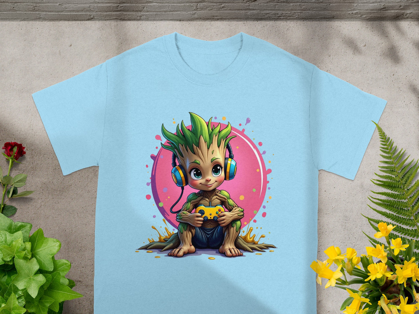 Baby Groot wearing headphones plays a video game on a light blue t-shirt.