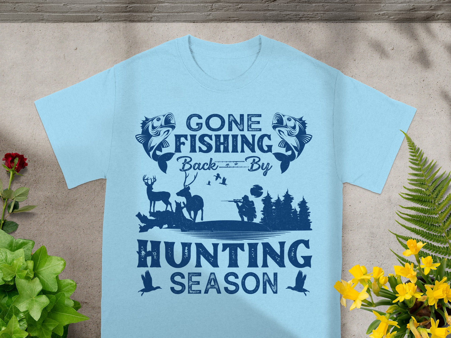 Light blue t-shirt with "Gone Fishing Back By Hunting Season" text and nature graphics.