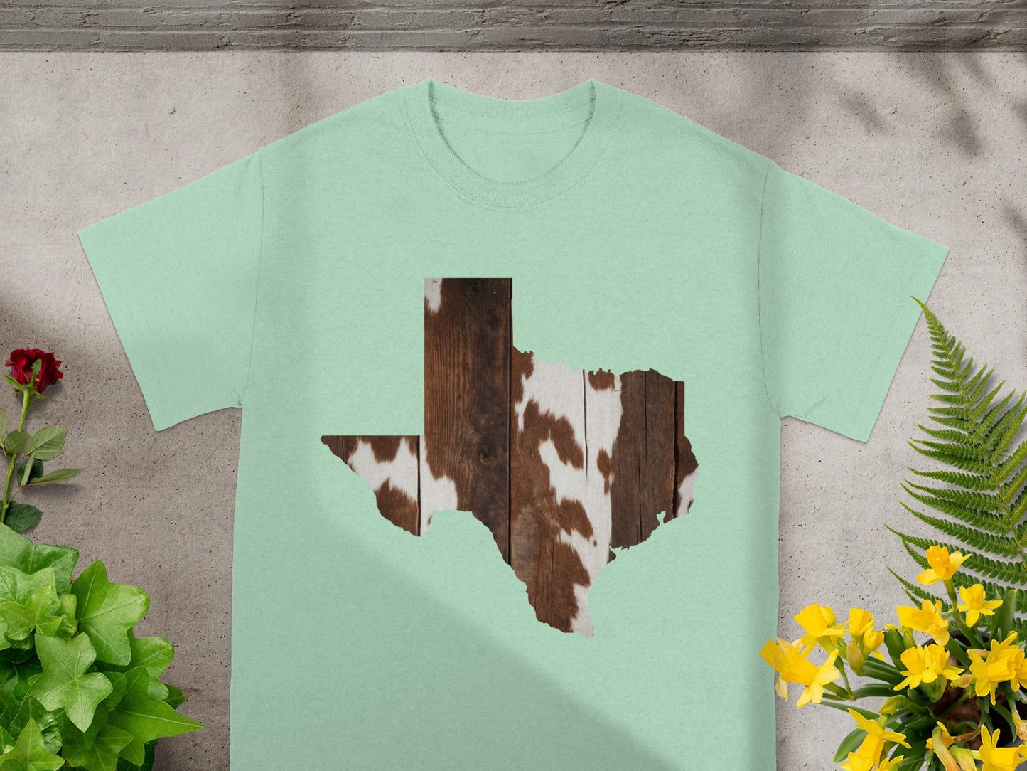 Light green t-shirt with Texas shape featuring wood and cowhide pattern.