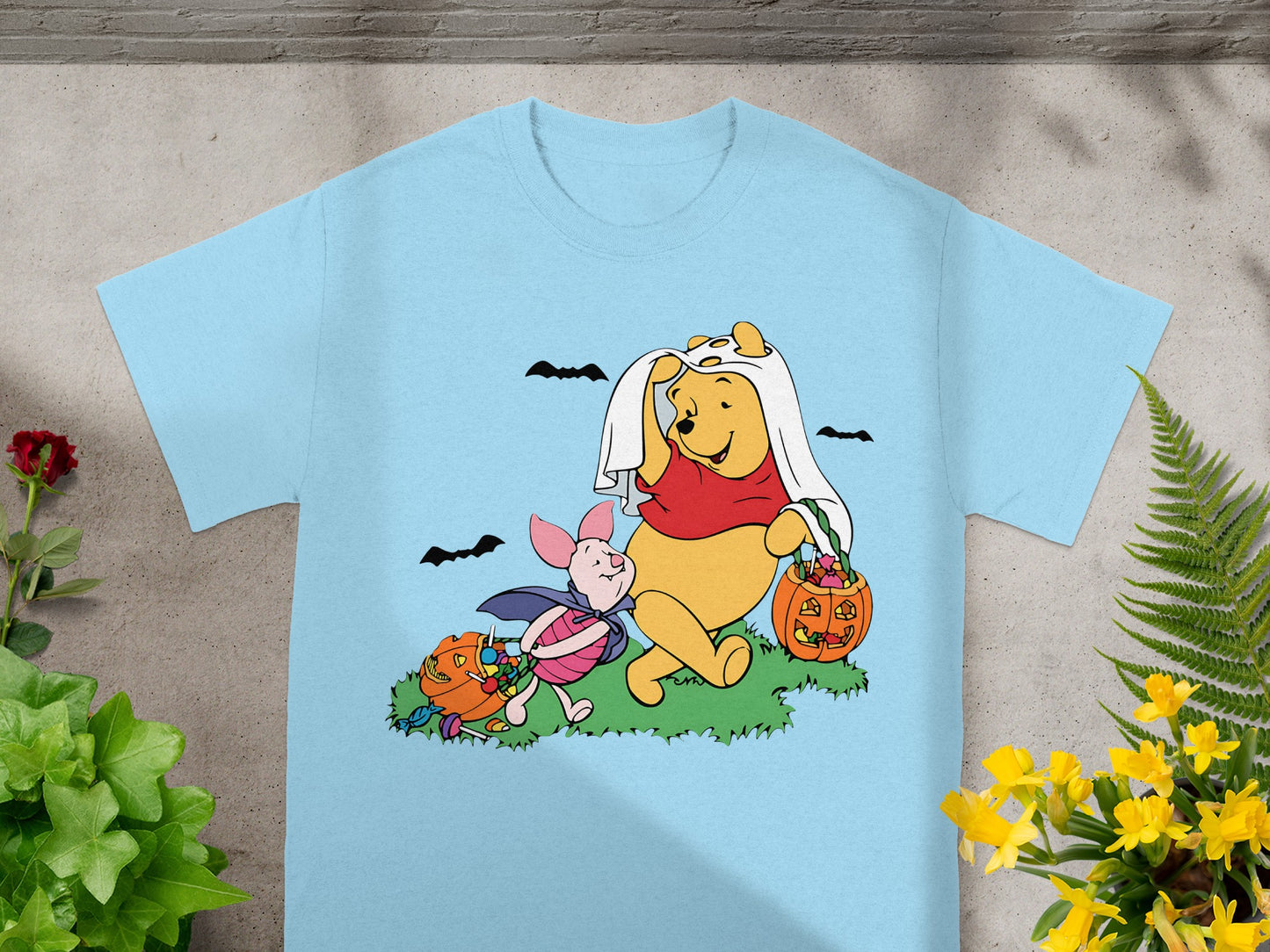Winnie the Pooh and Piglet in Halloween costumes with candy and pumpkins.