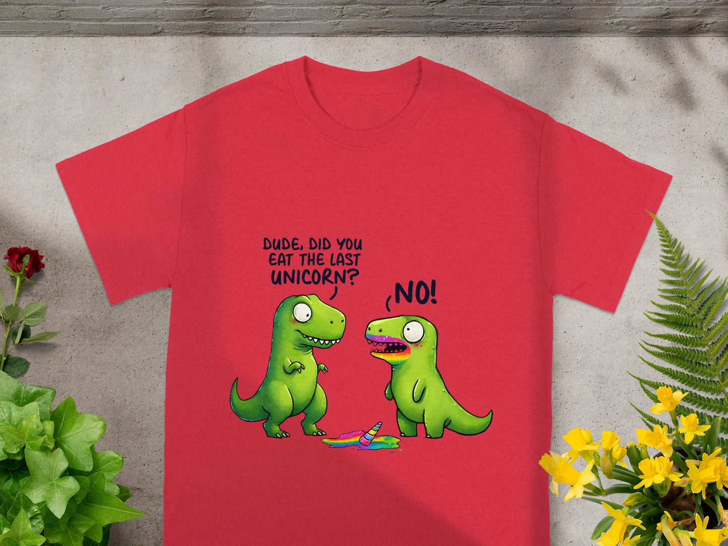 Red t-shirt with a graphic of two green dinosaurs and a melted unicorn.