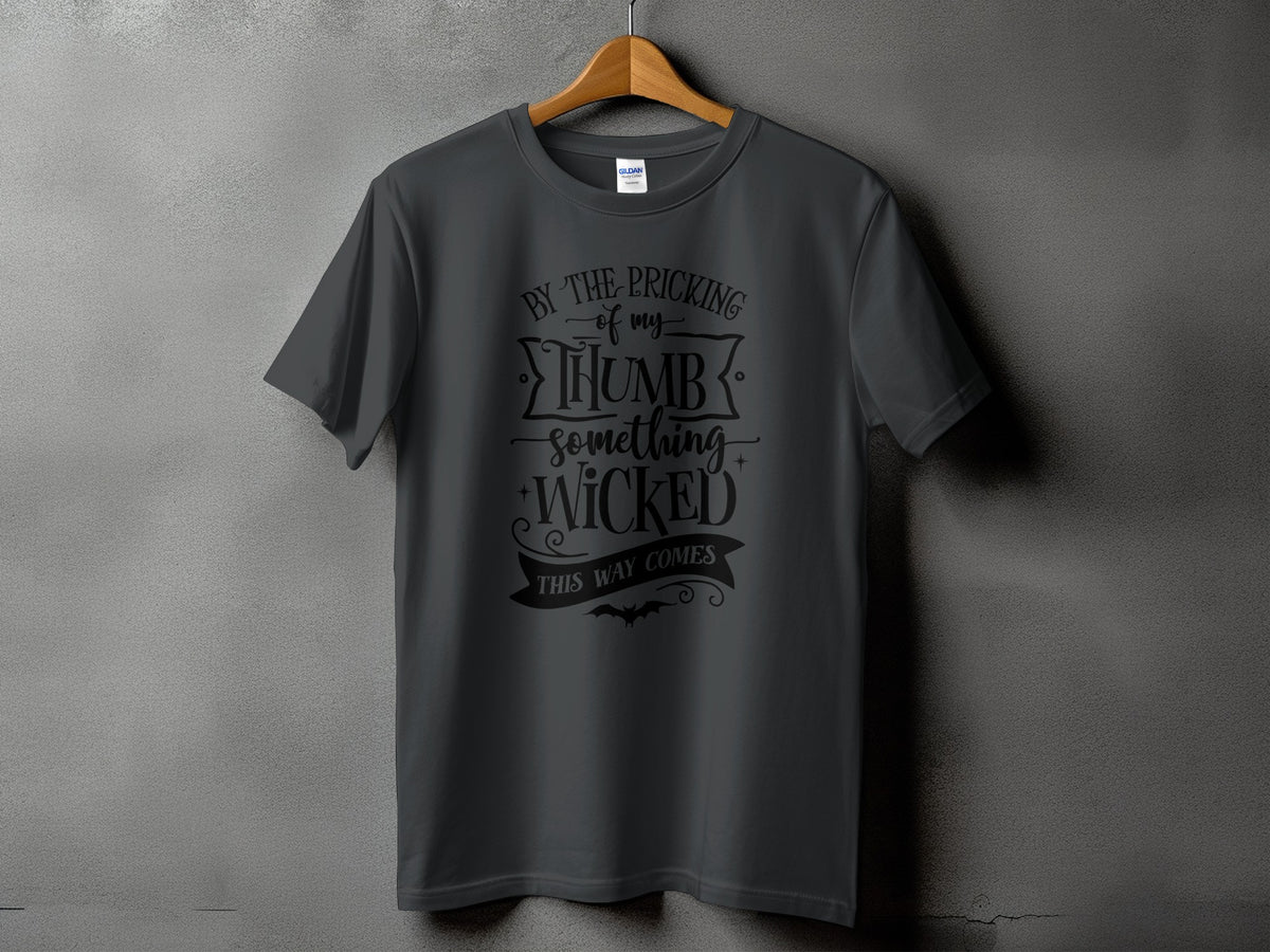 Dark gray t-shirt with black text: "By the pricking of my thumb, something wicked this way comes"