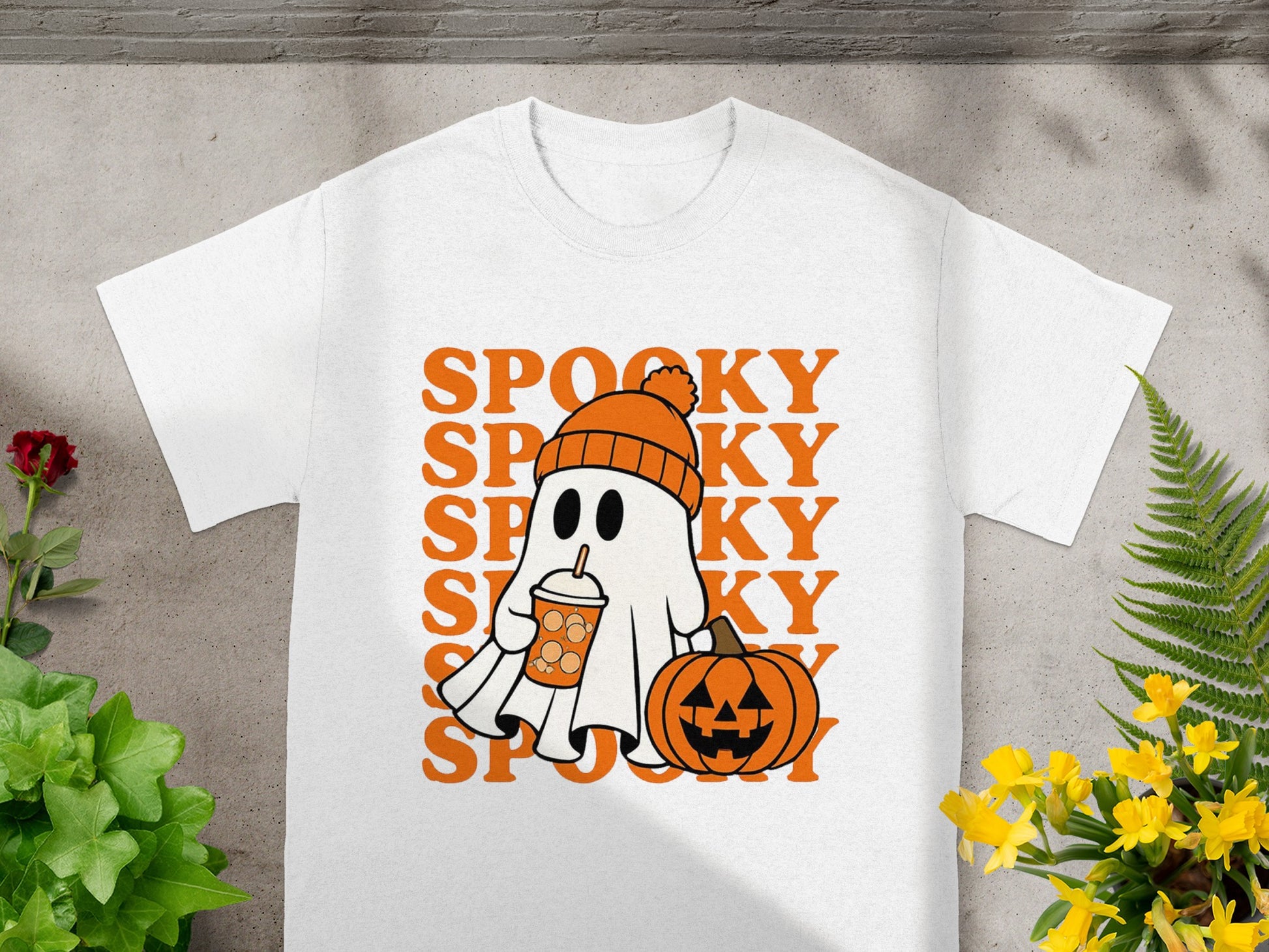 White t-shirt with "SPOOKY" text, a ghost with a drink, and a pumpkin.