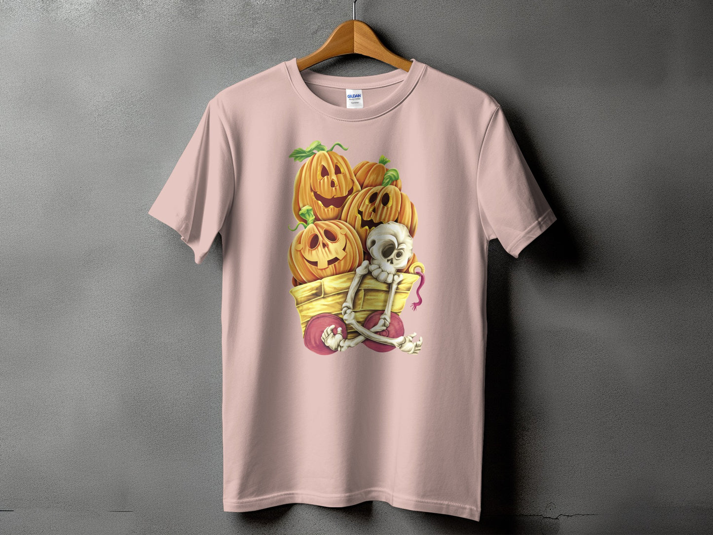 Pink t-shirt with a Halloween cart filled with carved pumpkins and a skeleton.