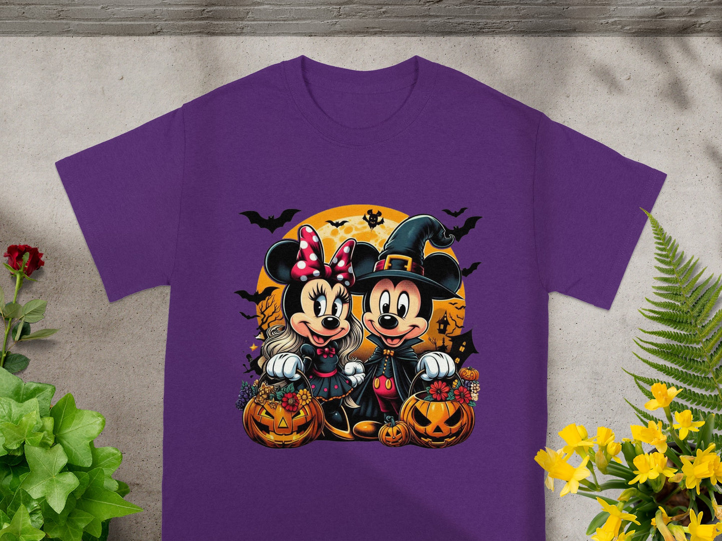 Mickey and Minnie Mouse in Halloween costumes with pumpkins and bats on a purple shirt.