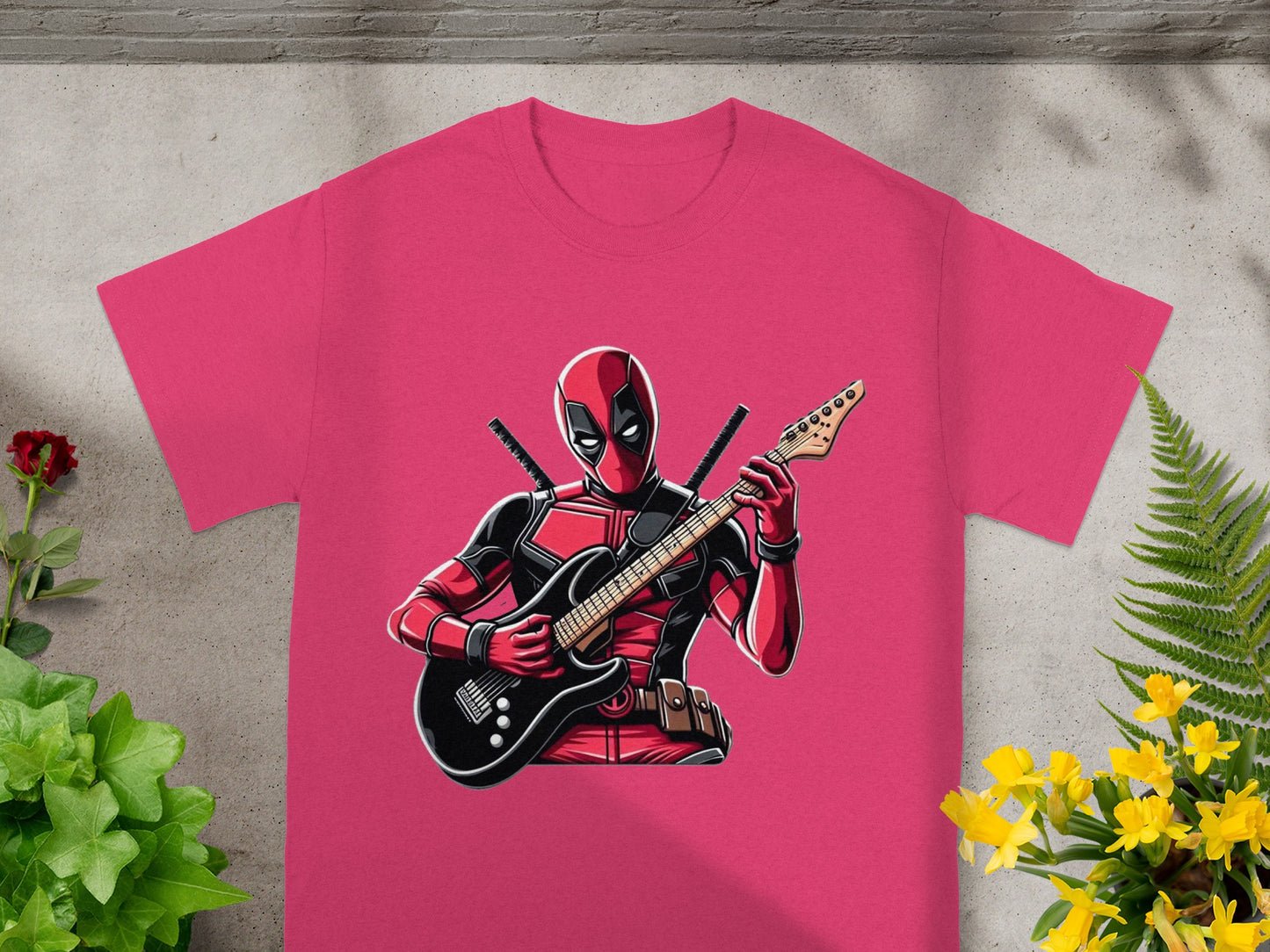 Pink t-shirt featuring Deadpool playing a black electric guitar.