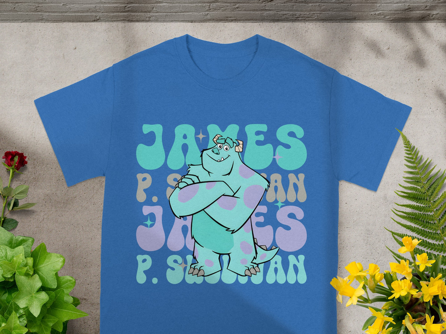 Blue t-shirt with "James P. Sullivan" text in stylized fonts.